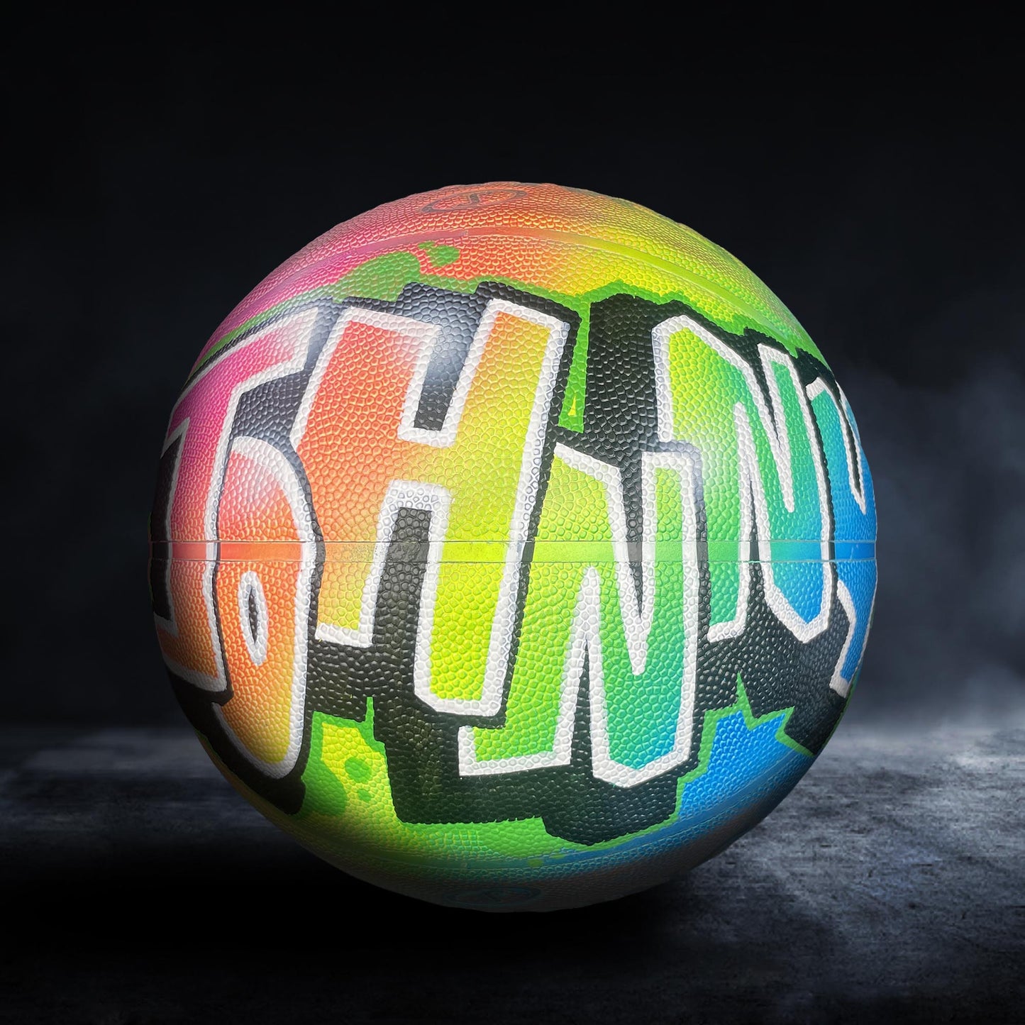 A colorful basketball with graffiti-style lettering on it.