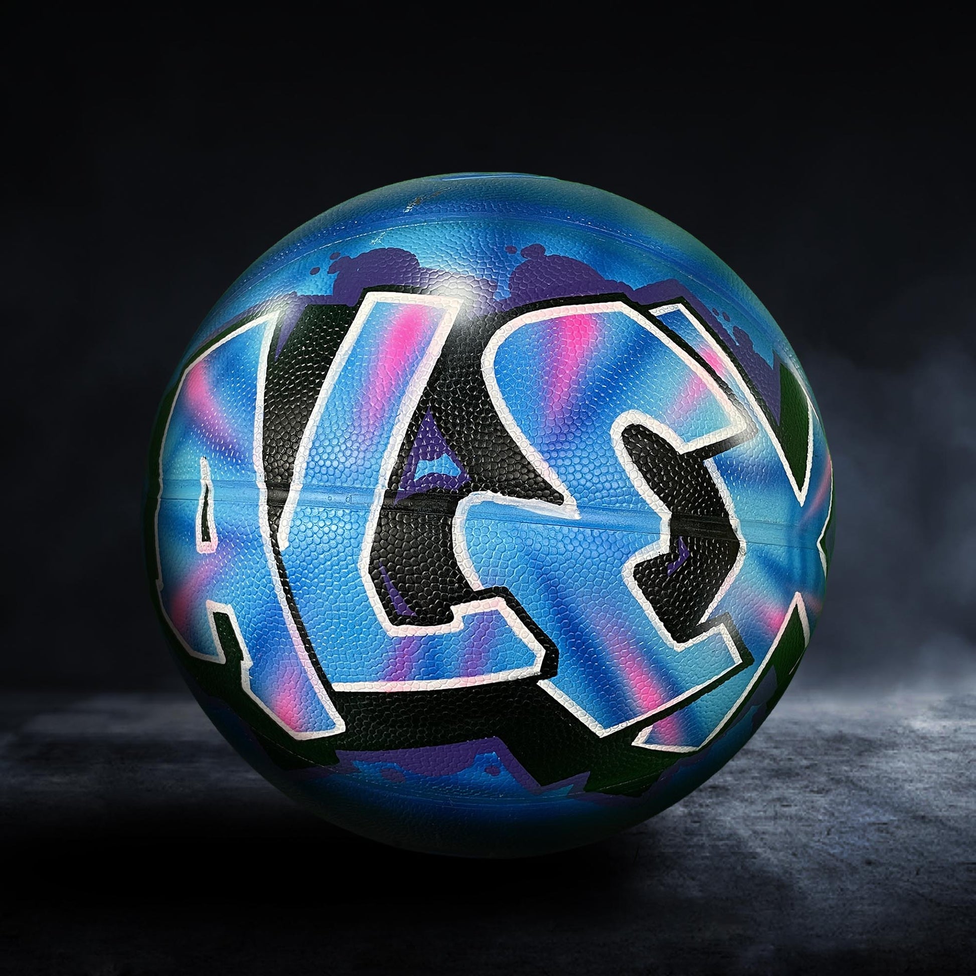 A basketball with the name "ALEX" painted on it in a colorful, graffiti-style design.