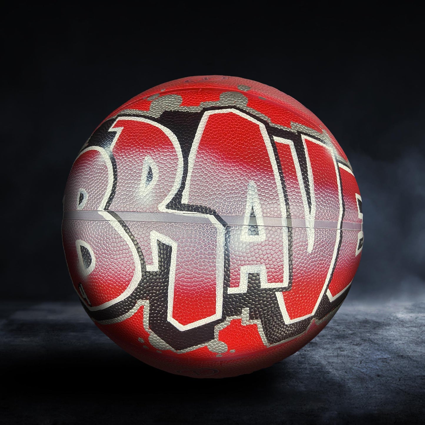 A red basketball with the word "BRAVE" written on it in graffiti-style lettering.