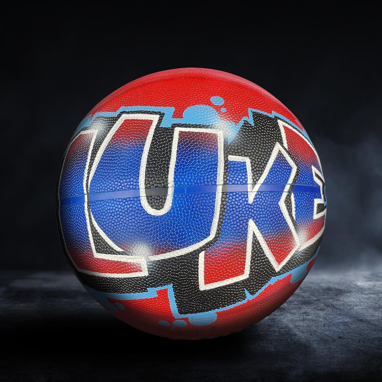 A basketball with the word "LUKEL" painted on it in a stylized, graffiti-like design.