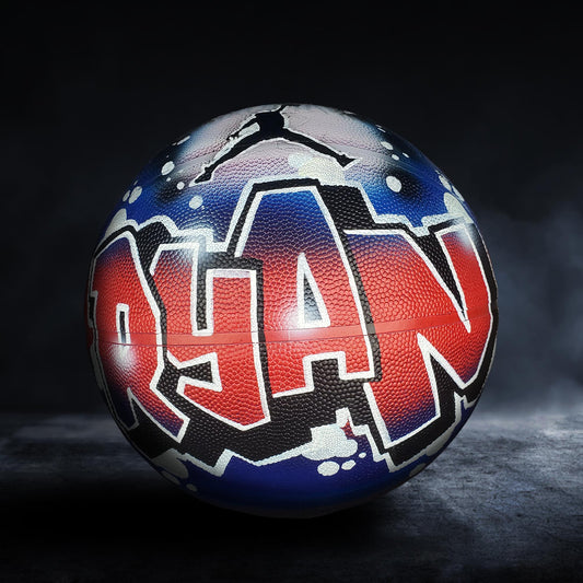 A basketball with the name "Ryan" painted on it in a colorful, graffiti-style design.