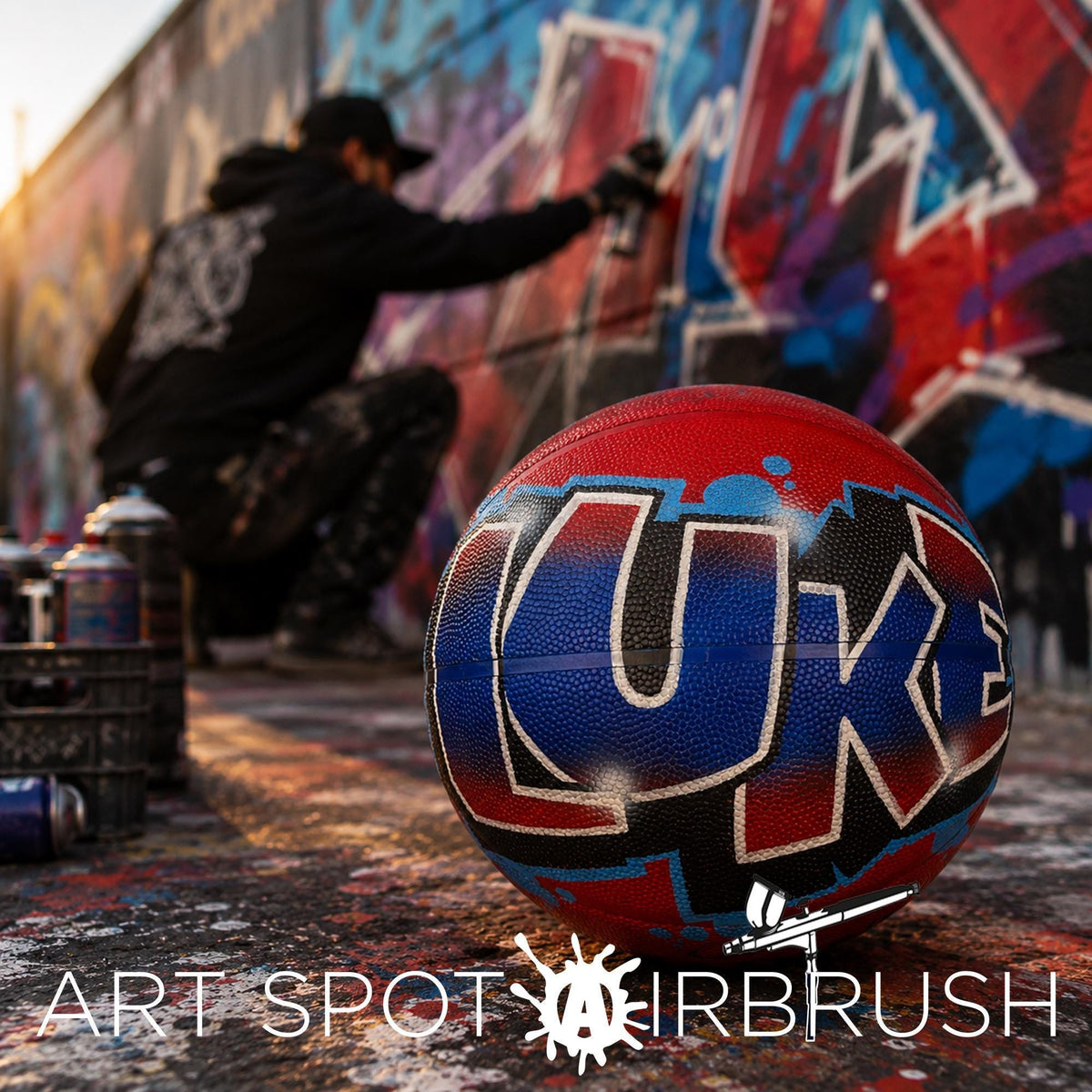 A person is spray painting a basketball with graffiti on it, while a basketball with the word "LUE" written on it is visible in the foreground.