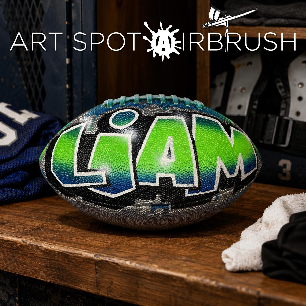 A personalized football with the name "Liam" painted on it, sitting on a wooden surface.