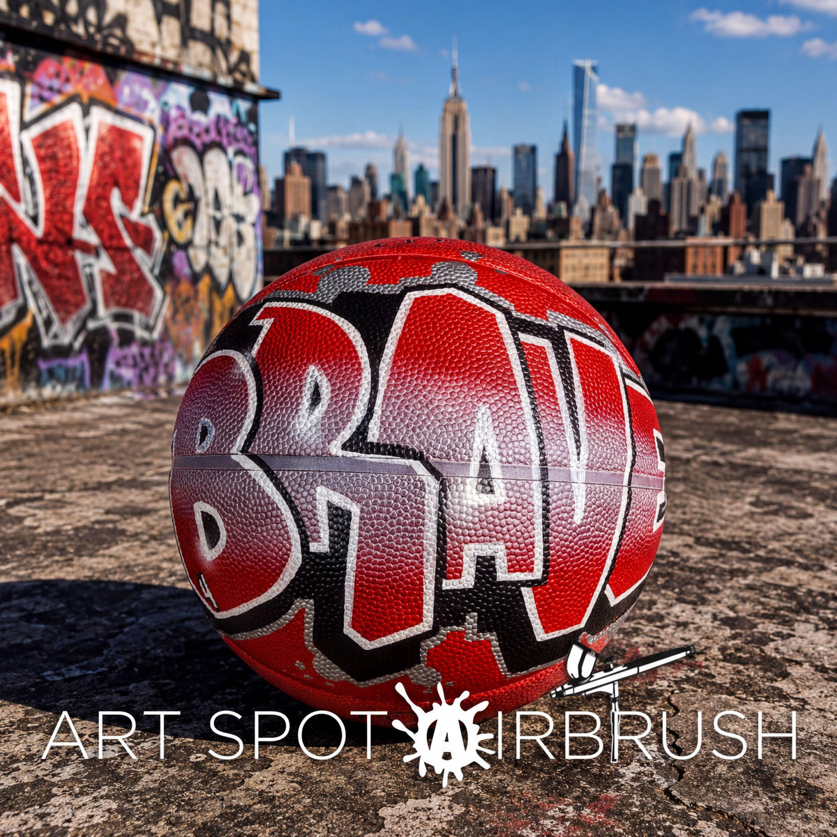A red basketball with the word "BRAV" painted on it, sitting on a rooftop with a city skyline in the background.