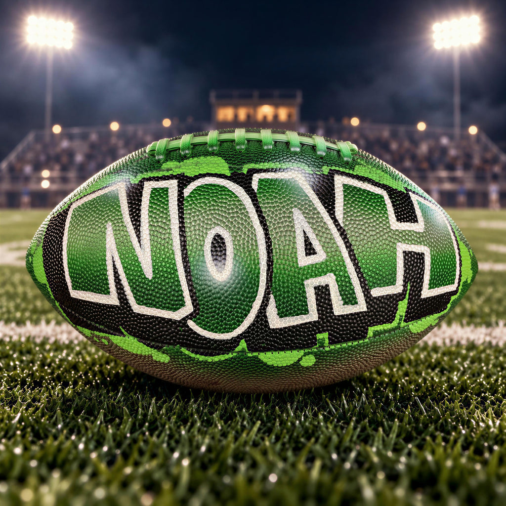 A green and black football with the word "Noah" painted on it, sitting on a grassy field at night with stadium lights in the background.
