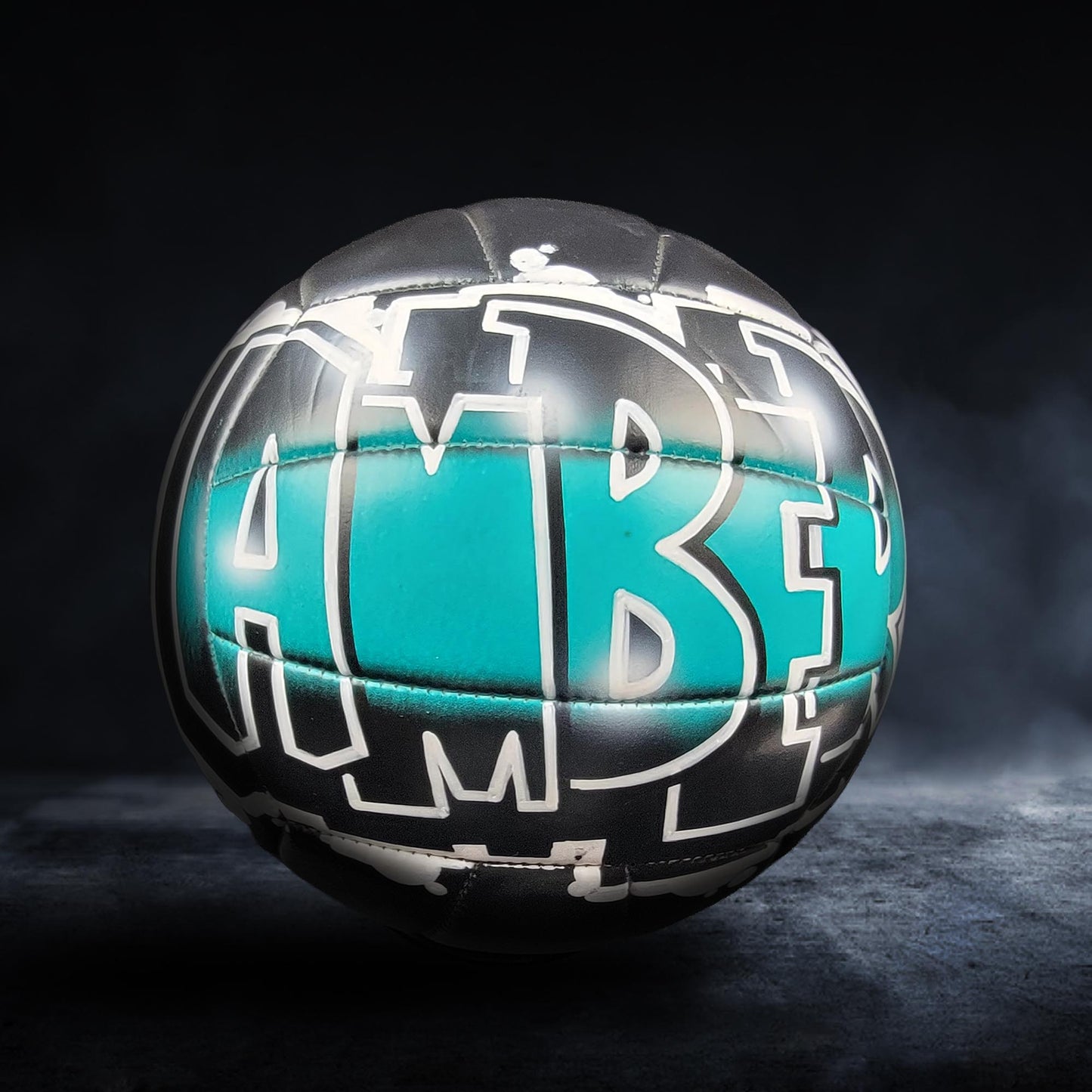 A soccer ball with the word "ABE" painted on it, set against a dark background.