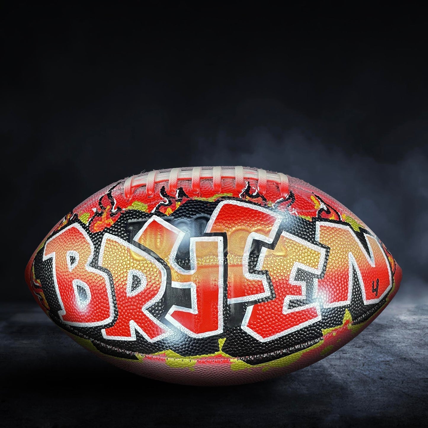 A football with the name "BREN" painted on it, featuring a colorful and artistic design.