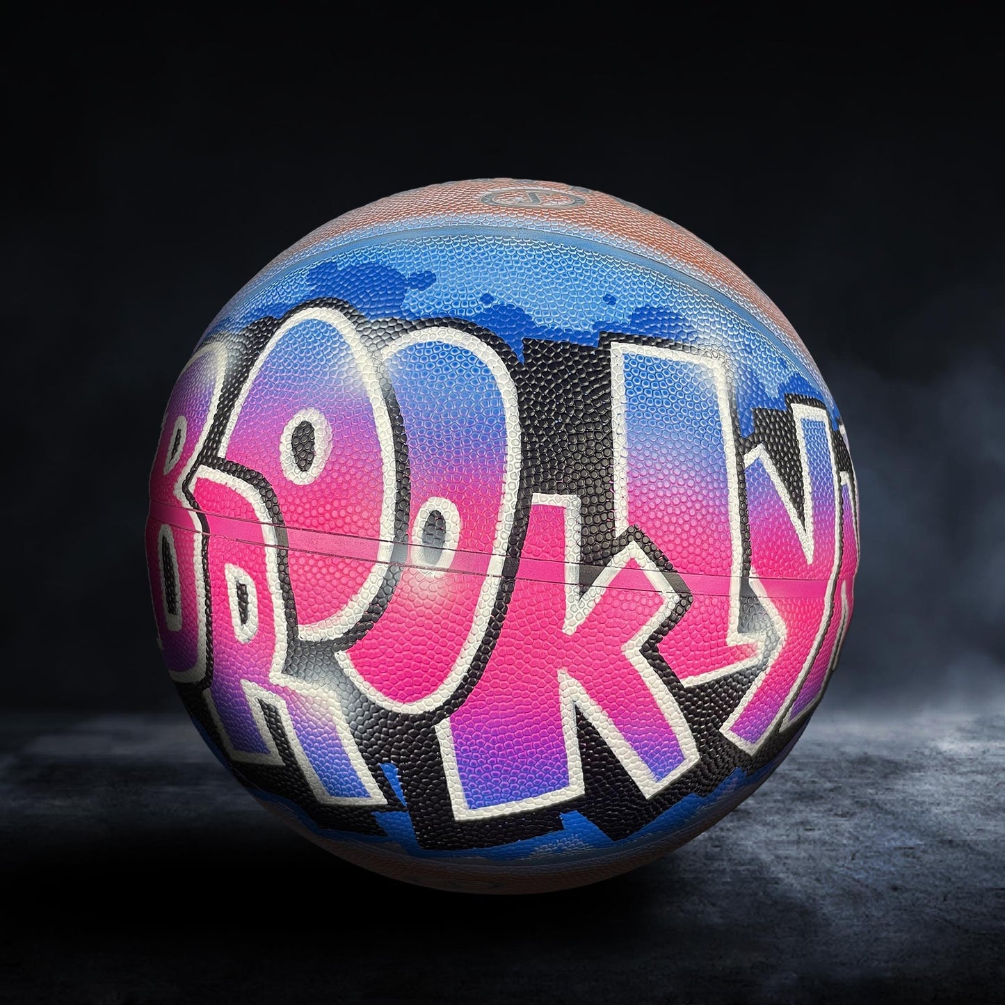 A basketball with the word "BROOKLYN" painted on it in a colorful, graffiti-style design.