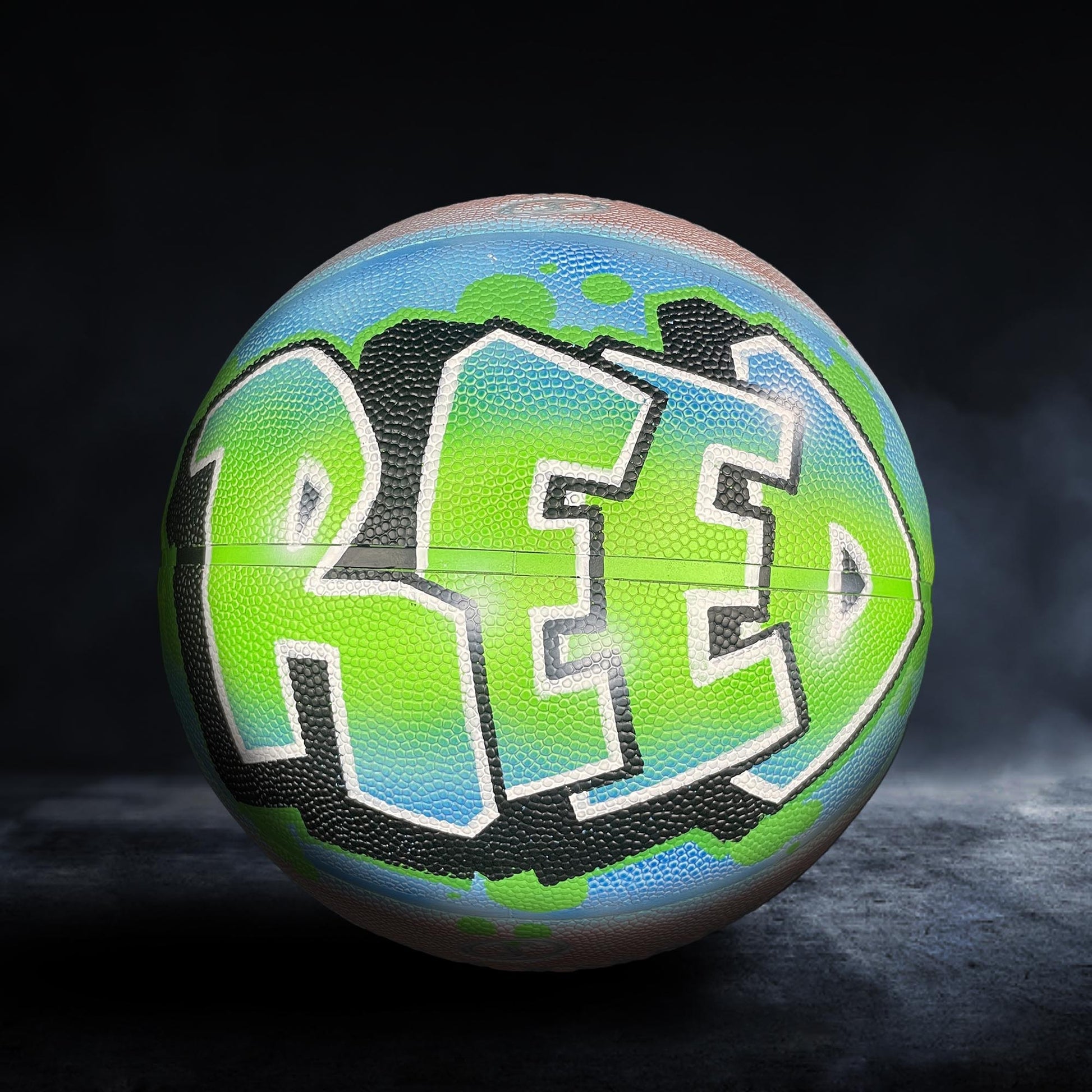 A basketball with the word "RED" painted on it in a stylized, graffiti-like design.