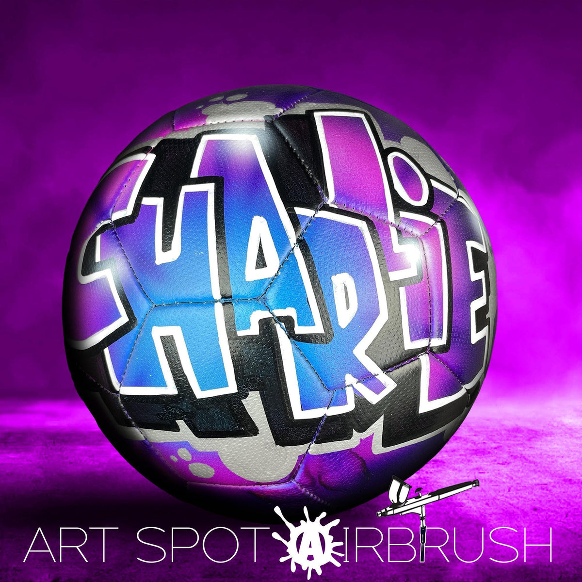 A soccer ball with the name "Harle" painted on it, set against a purple background.