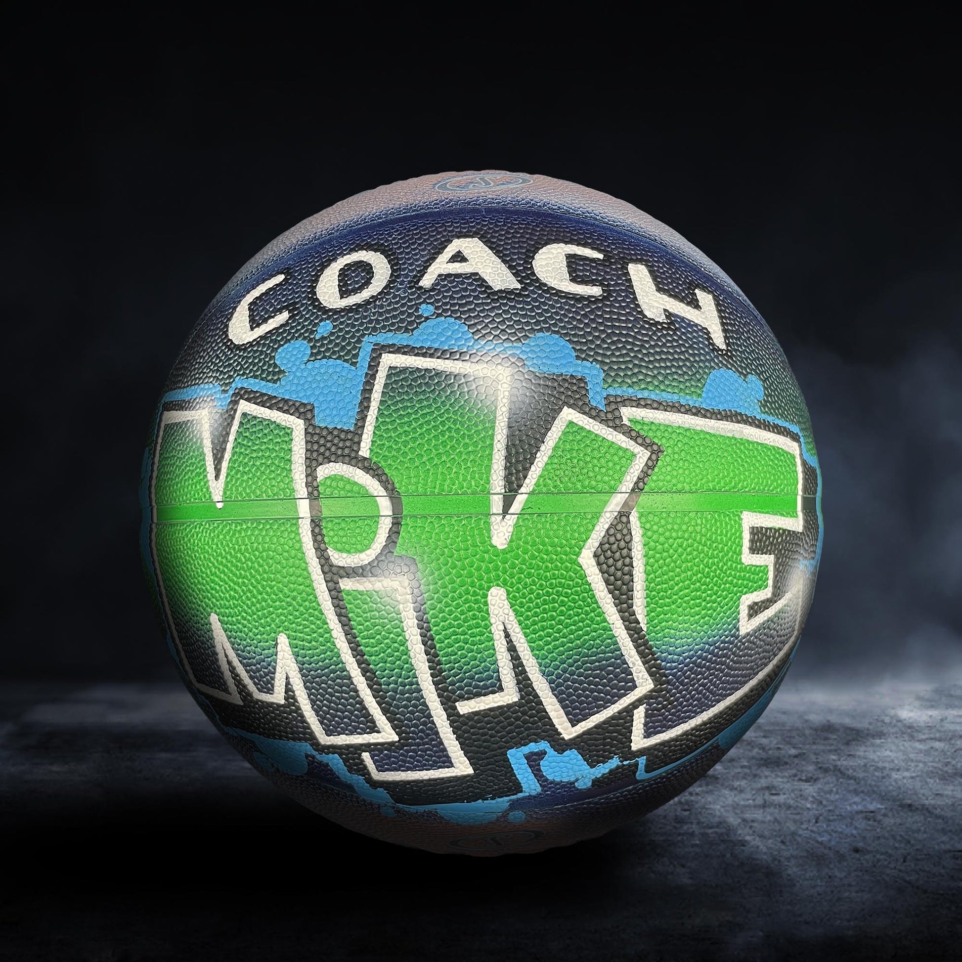 A basketball with the word "Mike" painted on it, featuring a colorful design with green and blue elements.