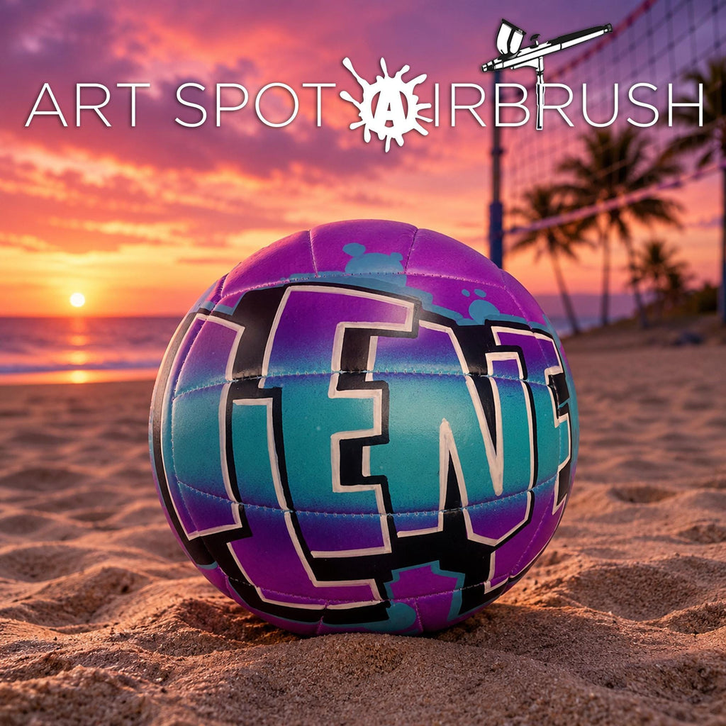 A colorful volleyball with the word "LEN" painted on it, resting on a sandy beach at sunset.
