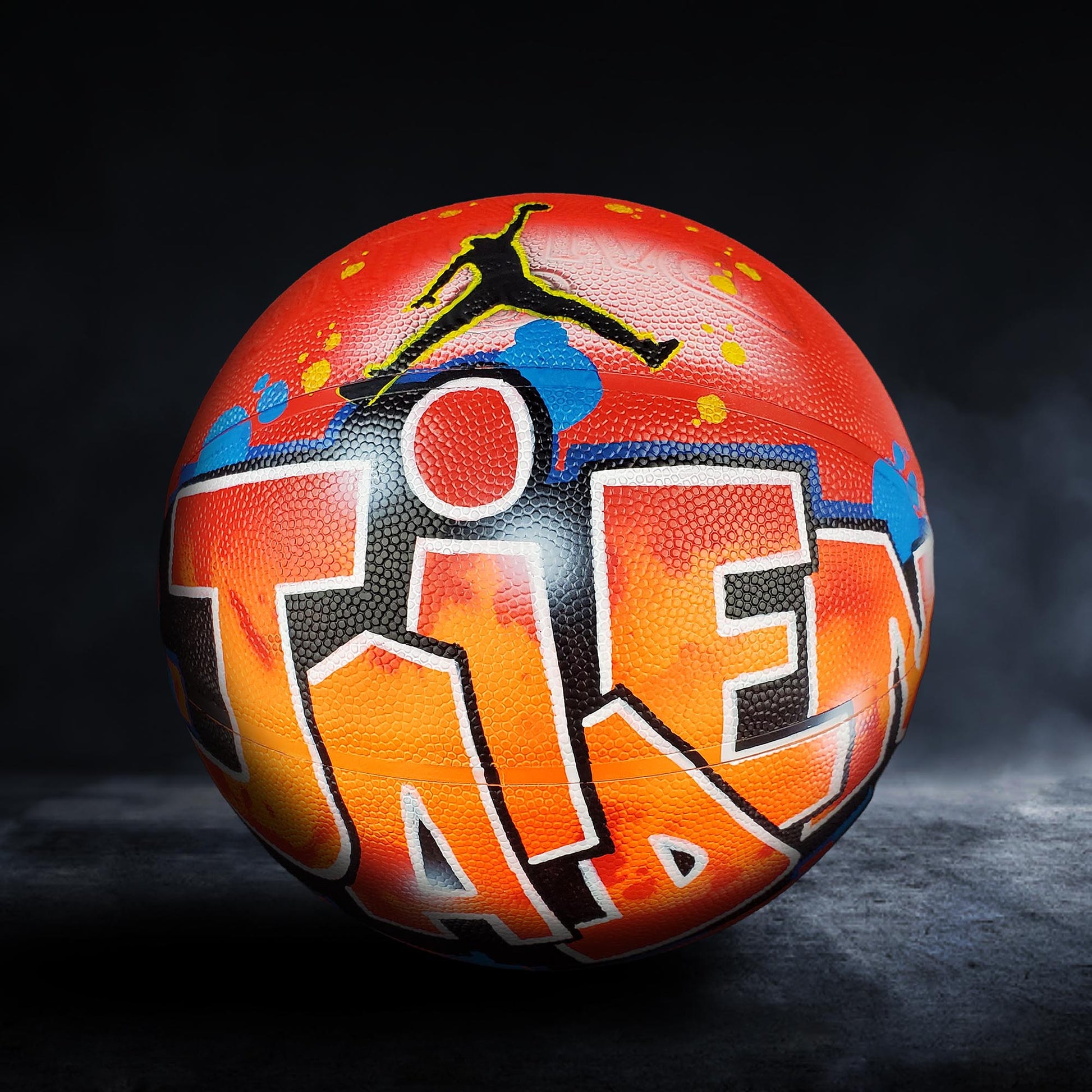 A basketball with a colorful, graffiti-style design on it, featuring the word "TAP" prominently displayed.