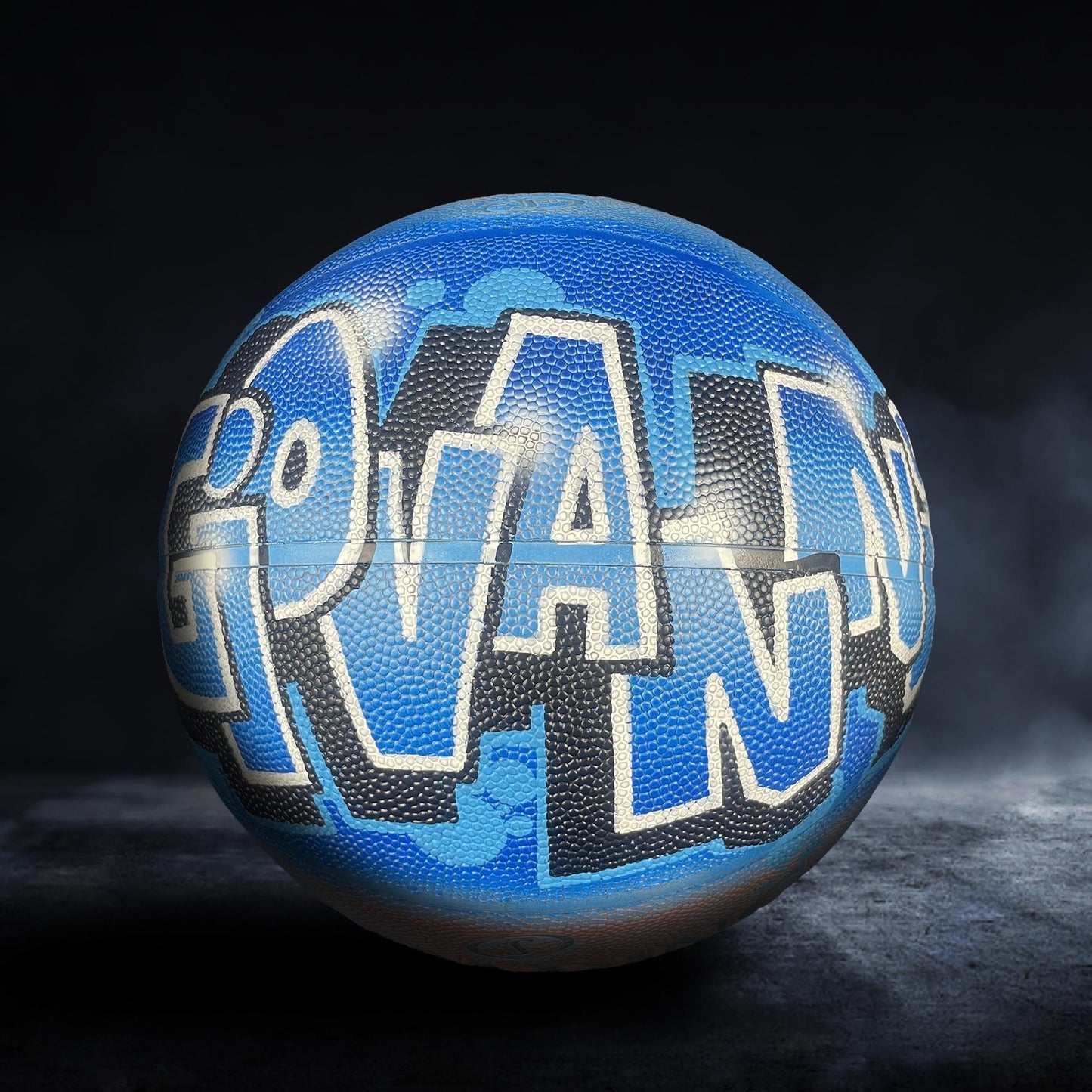 A blue basketball with the word "GRAND" written on it in white letters.