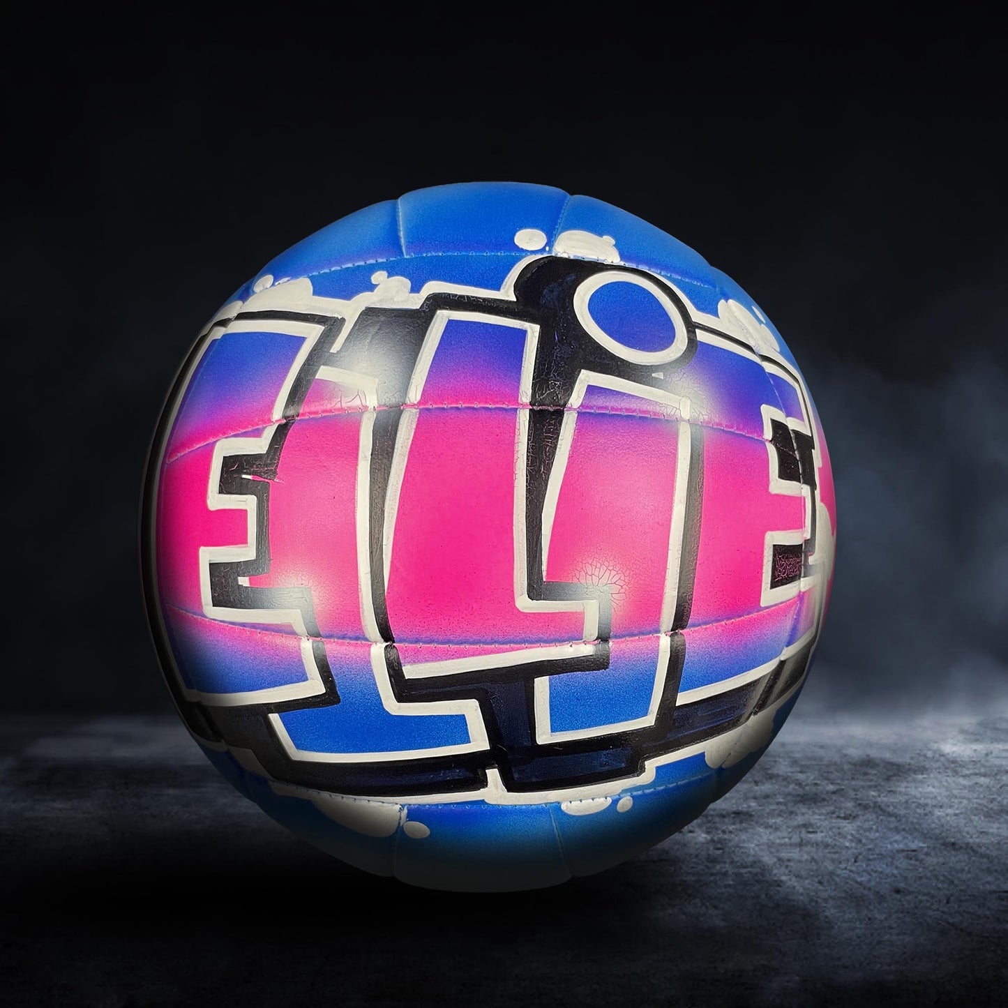 A colorful volleyball with the word "ELITE" painted on it, set against a dark background.