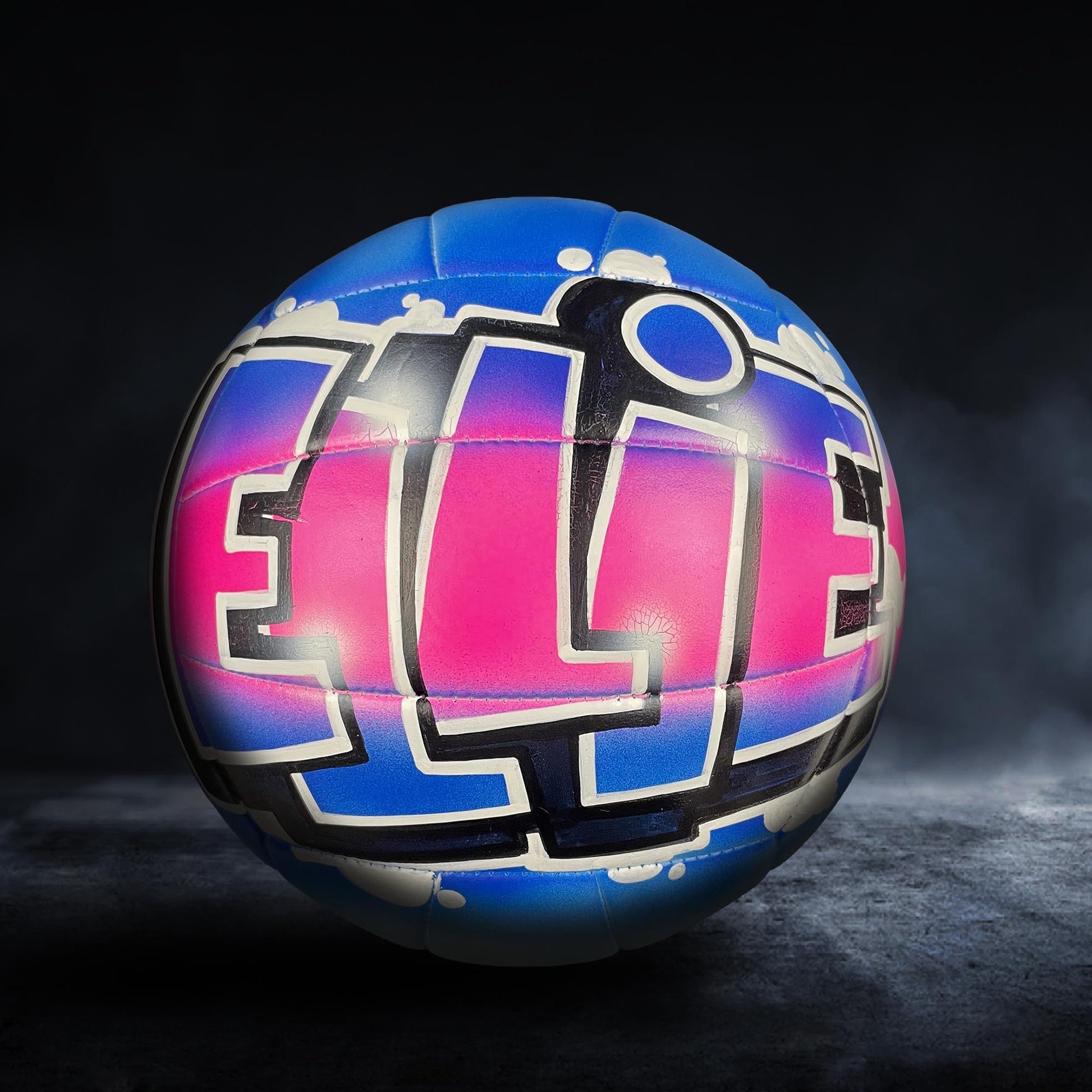 A colorful volleyball with the word "ELITE" painted on it, set against a dark background.