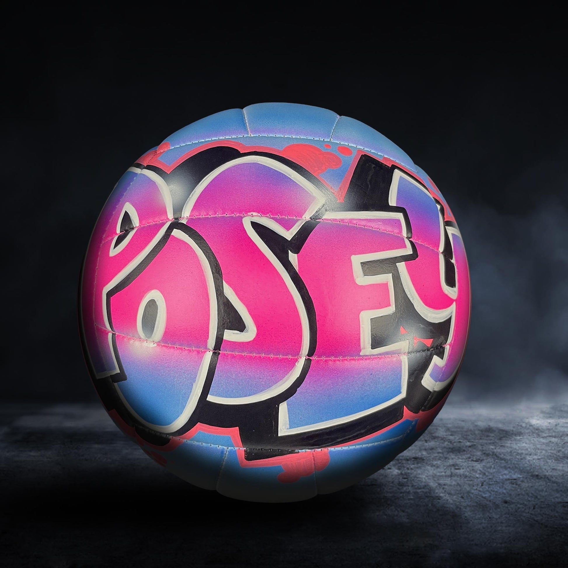 A colorful, graffiti-style volleyball with the word "Pose" painted on it, set against a dark background.