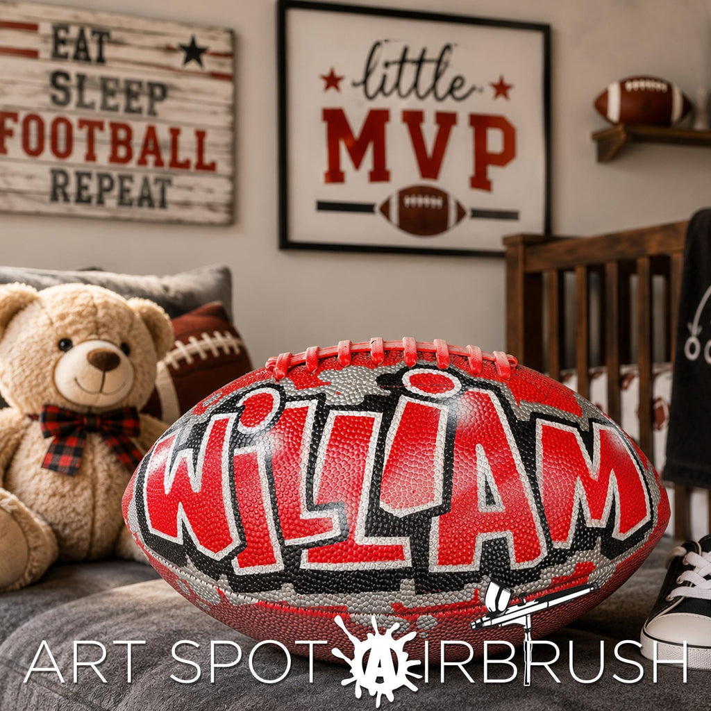 A bedroom with a teddy bear, a personalized custom football , and a framed sign with the word "little mvp" on it. The room also has a shelf with a football.