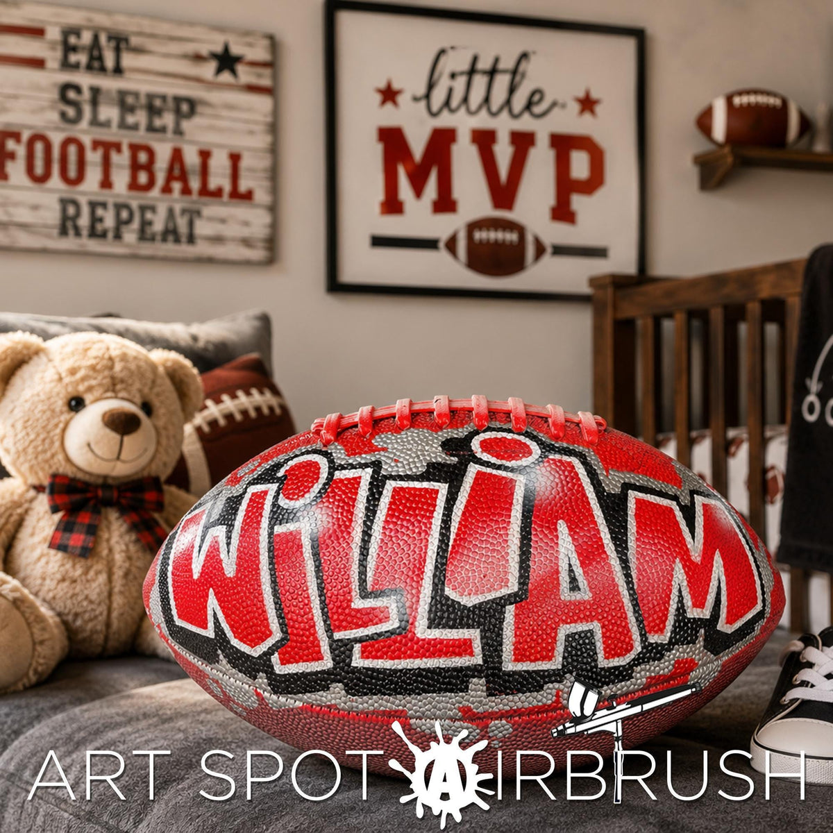 A bedroom with a teddy bear, a personalized custom football , and a framed sign with the word "little mvp" on it. The room also has a shelf with a football.