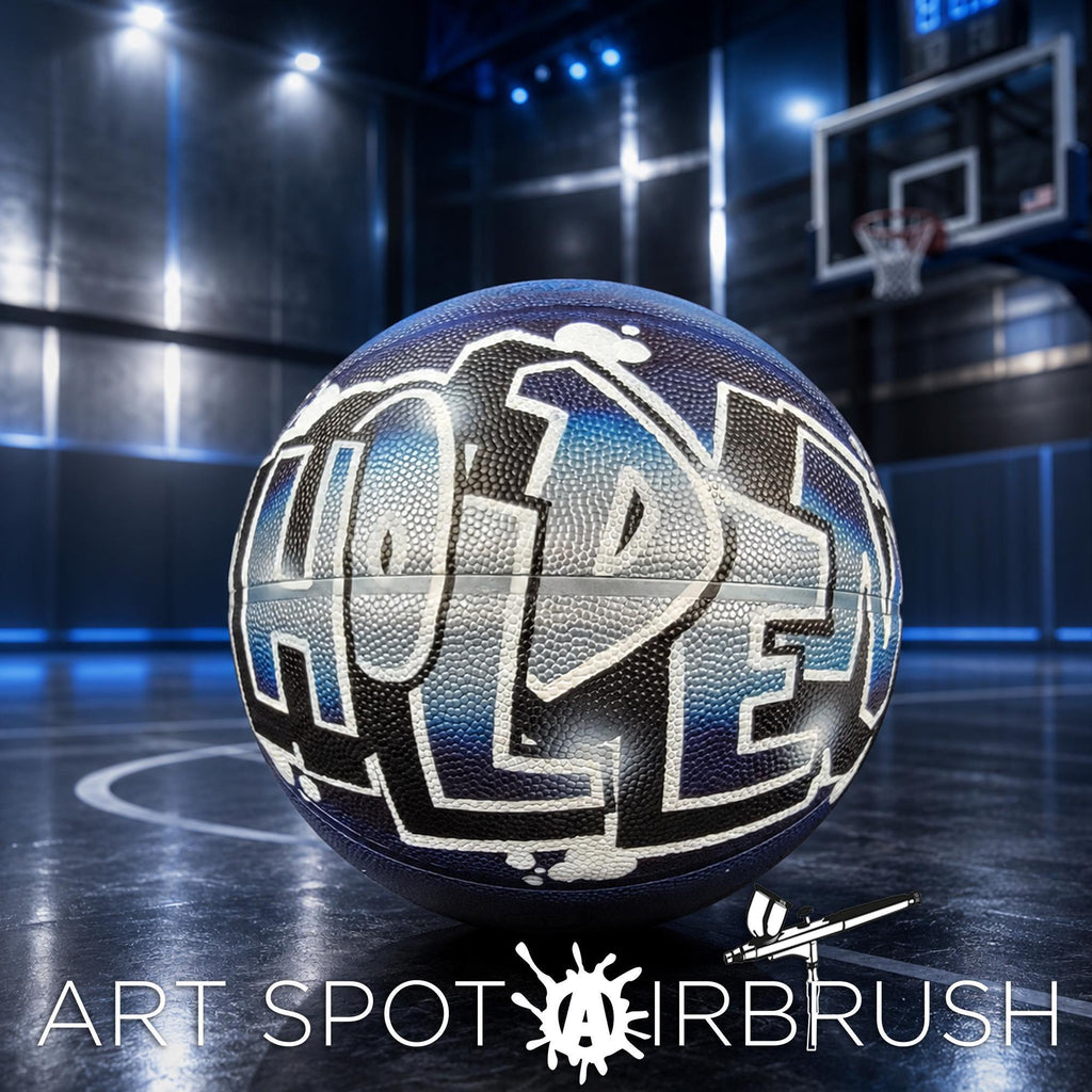 A basketball with the word "HOLDE" painted on it, sitting on a basketball court with a basketball hoop visible in the background.