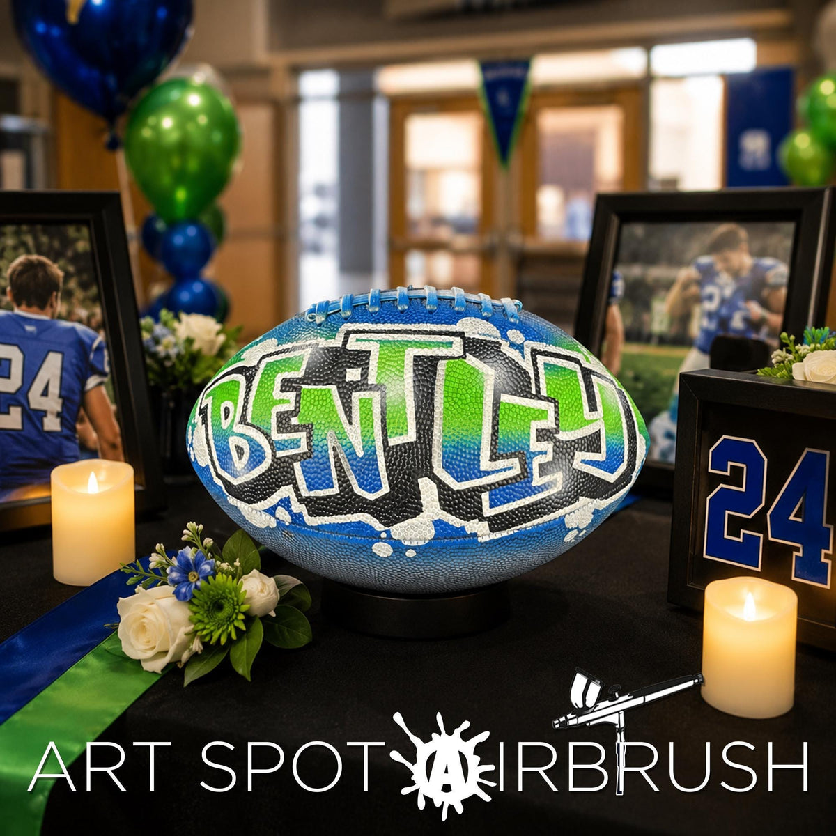a personalized custom football with the word "BENTLEY" painted on it, surrounded by various decorations such as balloons, flowers, and candles. The setting appears to be a sports-themed event or celebration.