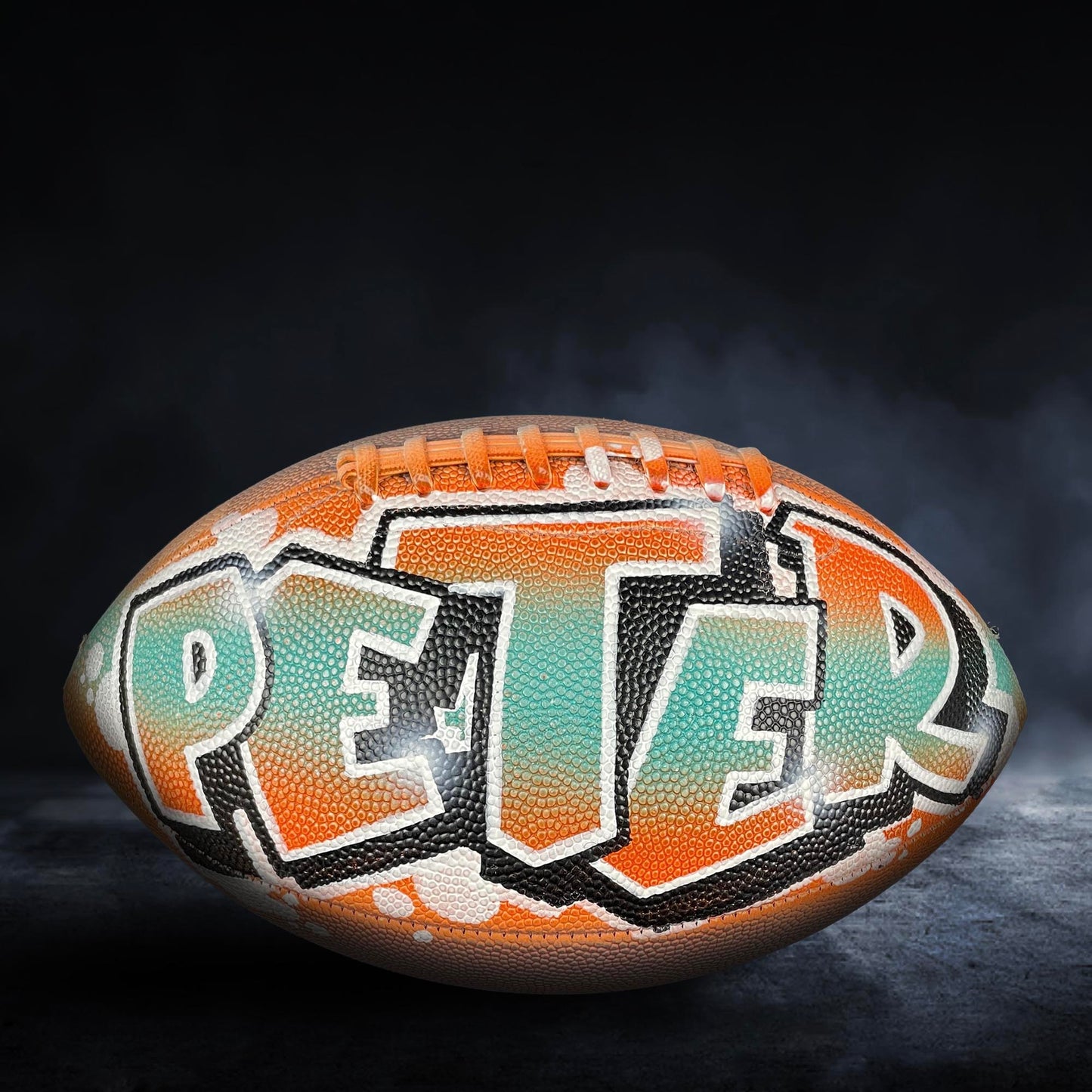 A personalized football with the name "PETER" painted on it.