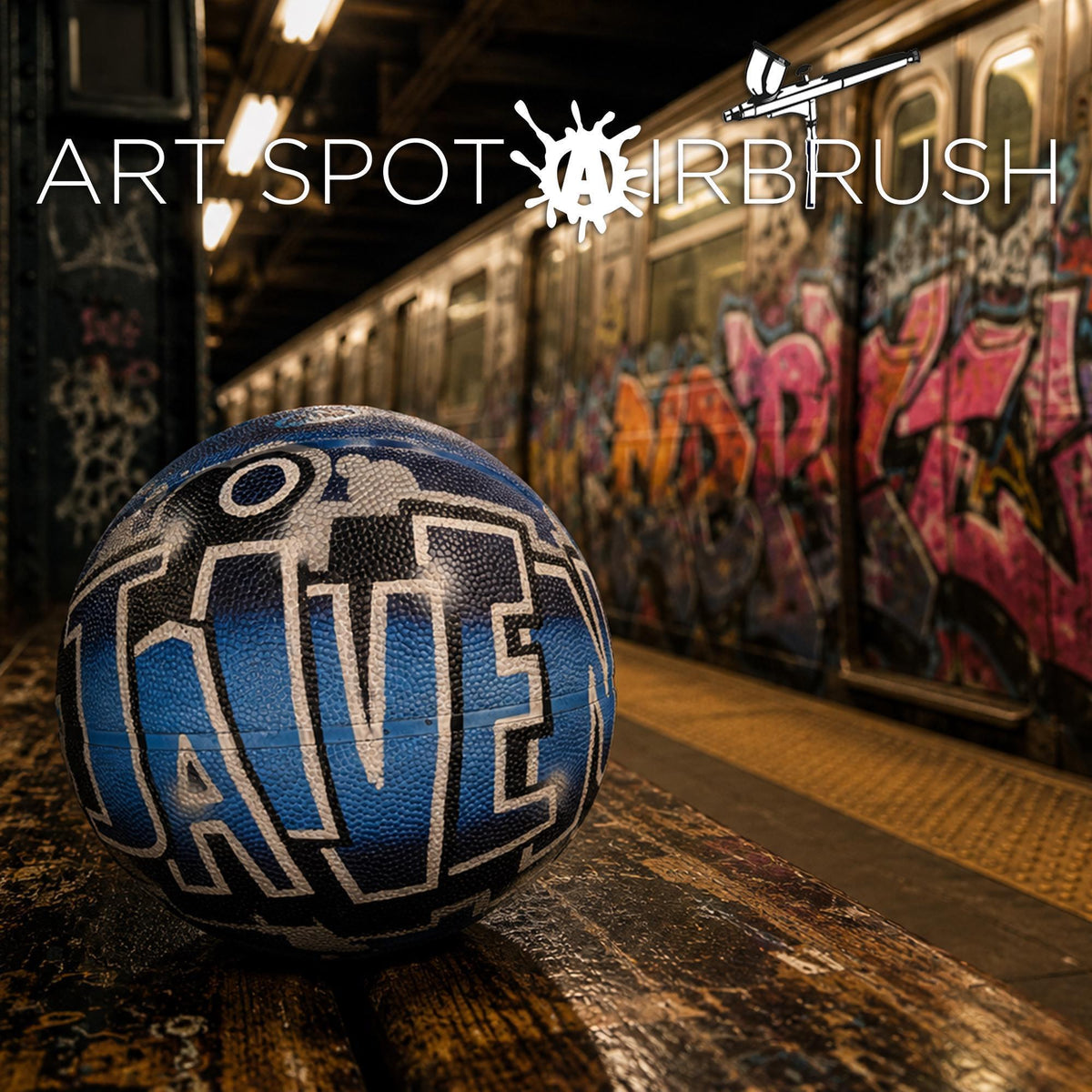 a blue basketball with the word "JANE" painted on it, sitting on a wooden bench in an urban setting with graffiti-covered walls in the background.