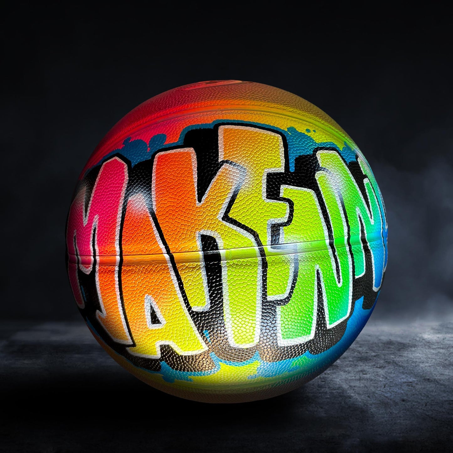 A colorful basketball with the word "MAKE" painted on it.