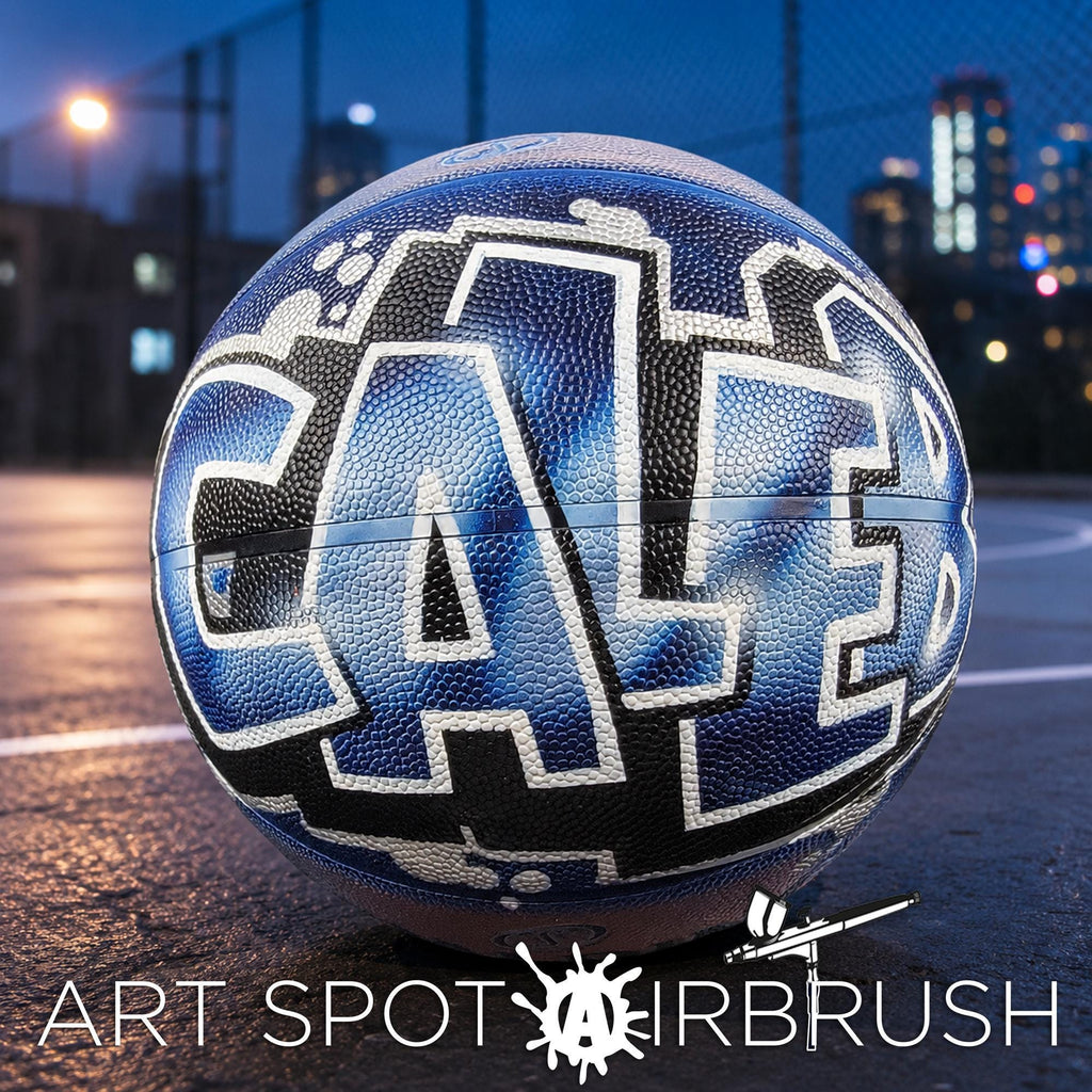 A basketball with the word "CAL" painted on it, sitting on a basketball court at night.