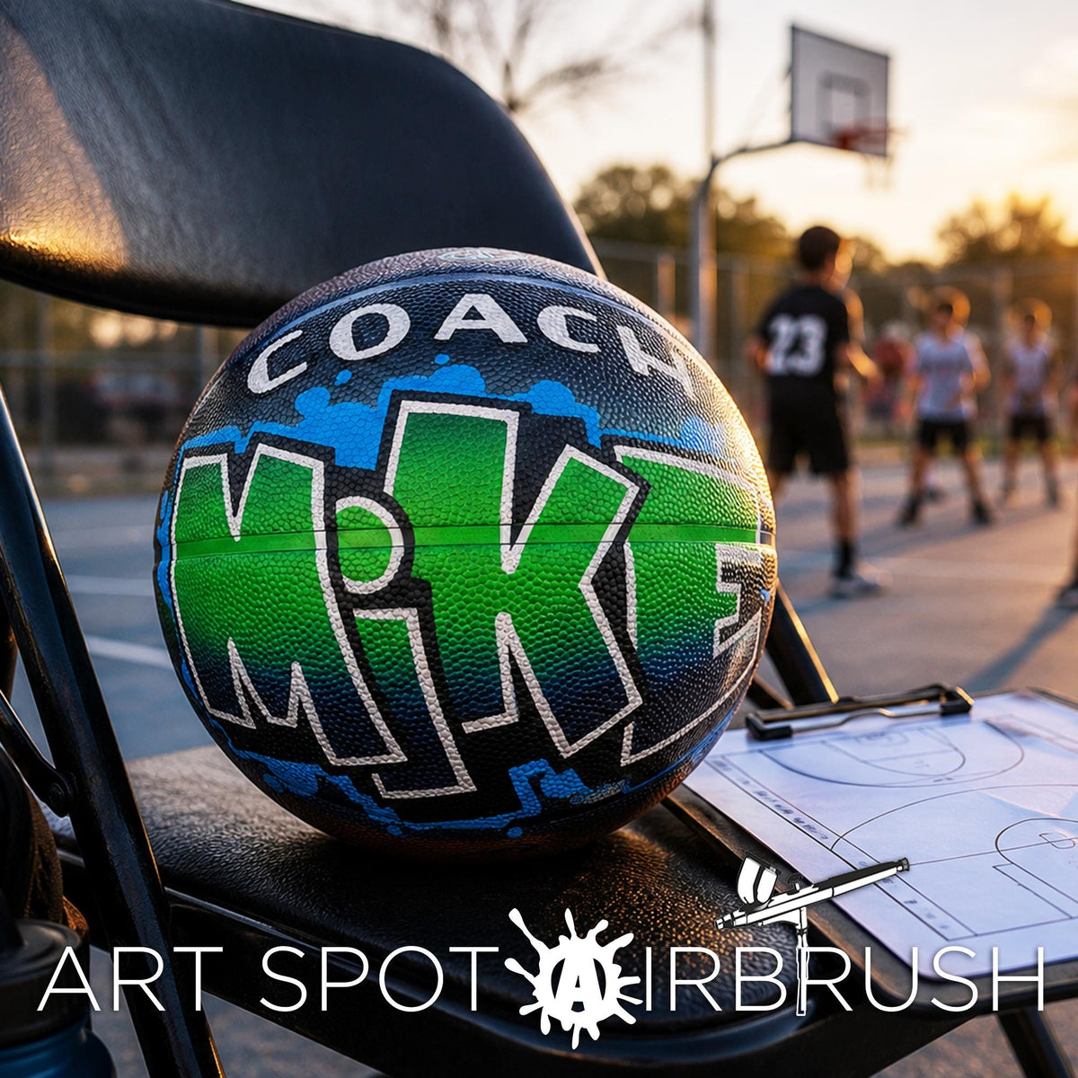 A basketball with the word "Mik" painted on it, sitting on a black folding chair in an outdoor setting with a basketball hoop and people playing basketball in the background.