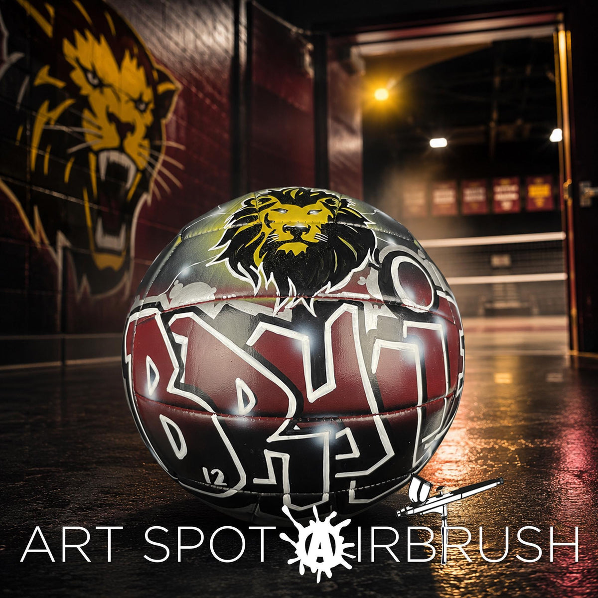 A custom volleyball with a lion logo on it, placed on a dark surface with a graffiti-style wall in the background.