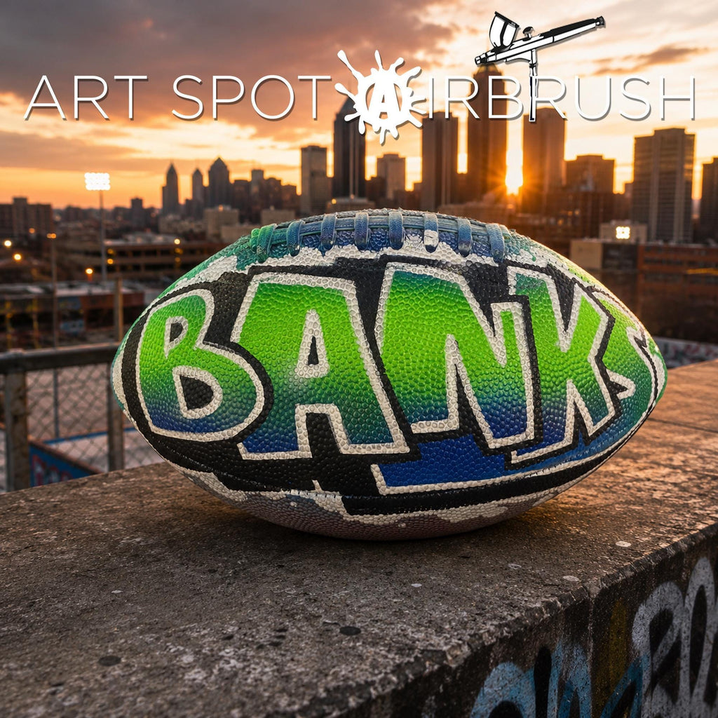 a personalized custom football with the word "BANKS" painted on it, set against the backdrop of a city skyline at sunset.