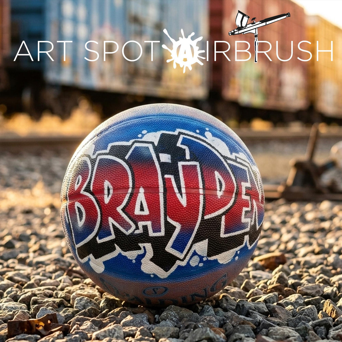 A basketball with the word "BRAV" painted on it, sitting on a bed of rocks.