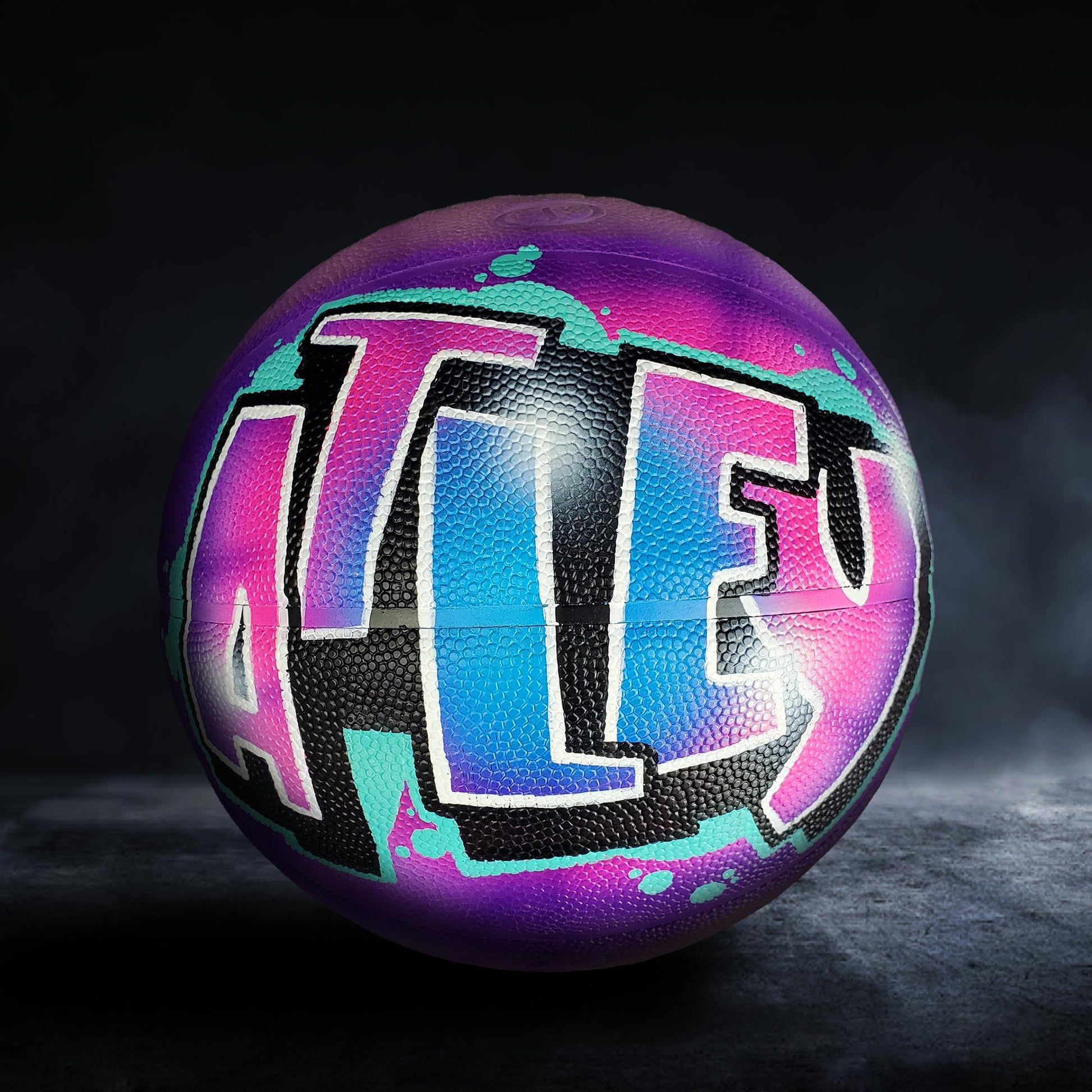 A basketball with a colorful graffiti design on it.