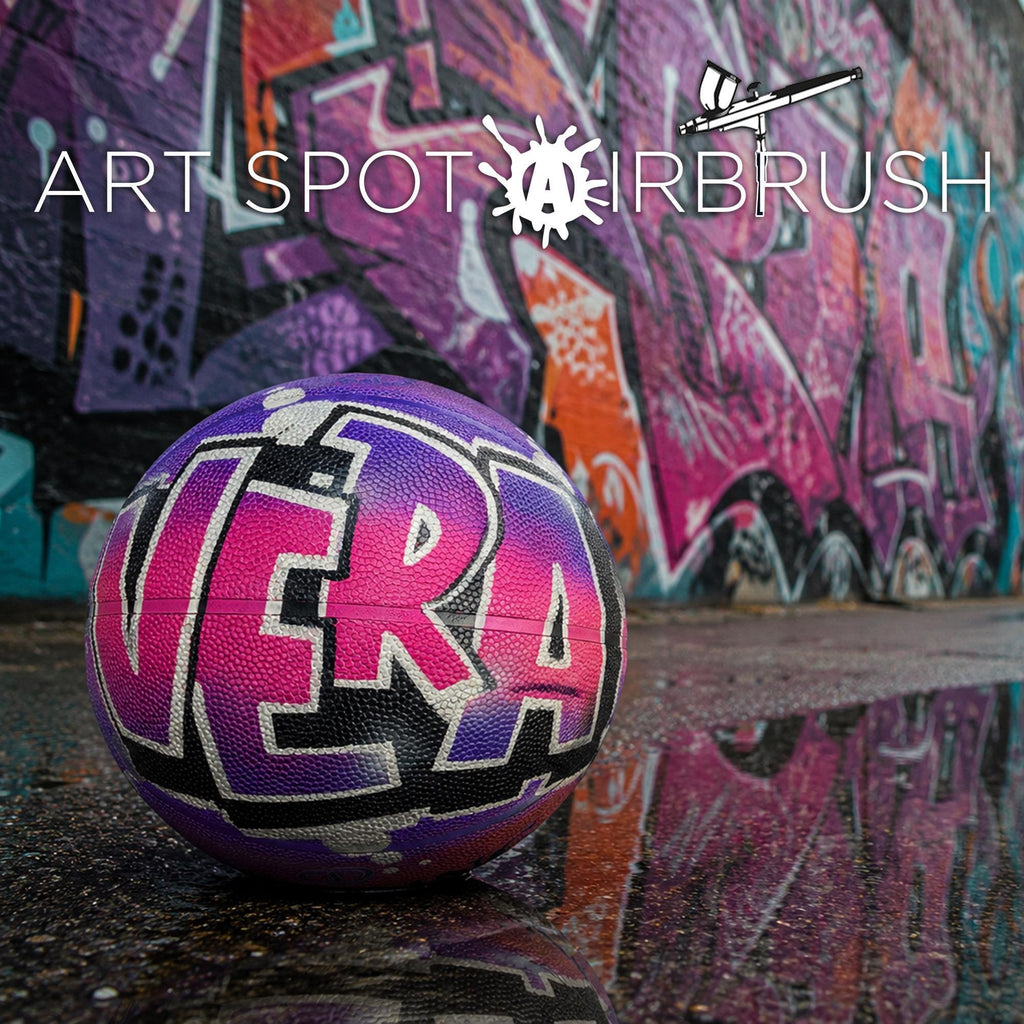 A colorful sports ball with the word "VERA" painted on it, placed on a reflective surface in front of a vibrant graffiti wall.