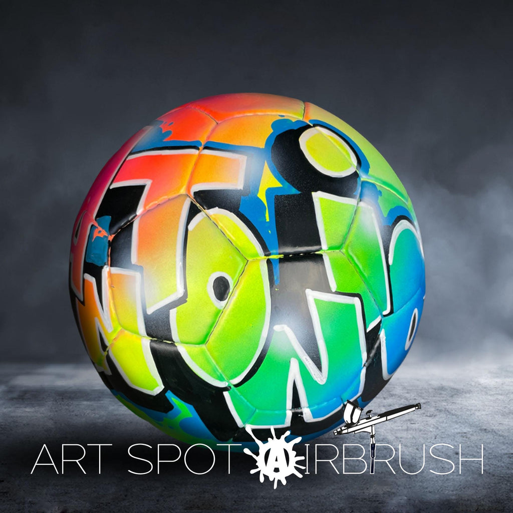 A colorful, graffiti-style soccer ball with the text "ART SPOT AIRBRUSH" displayed on it.