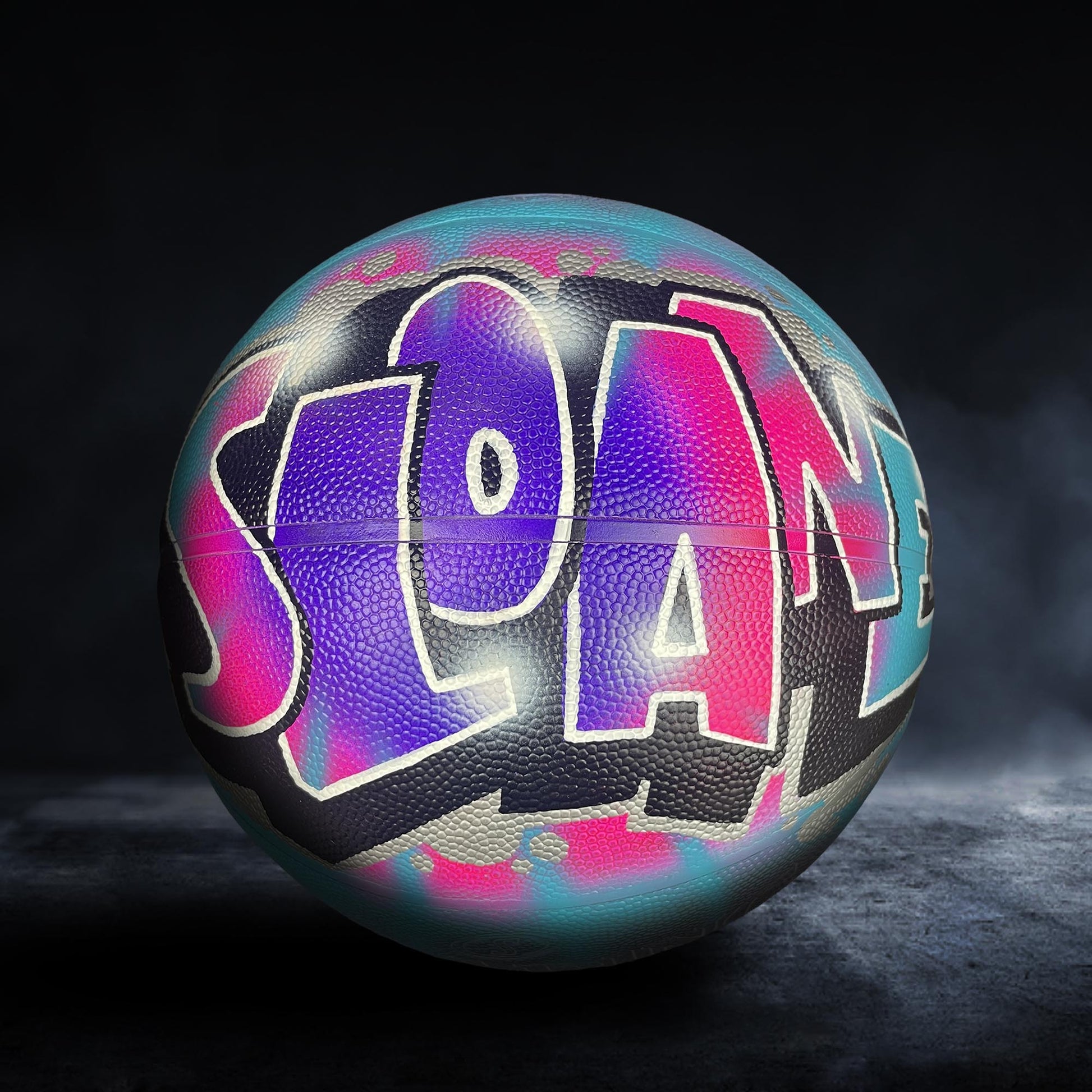 A colorful basketball with the word "SLOAN" painted on it.