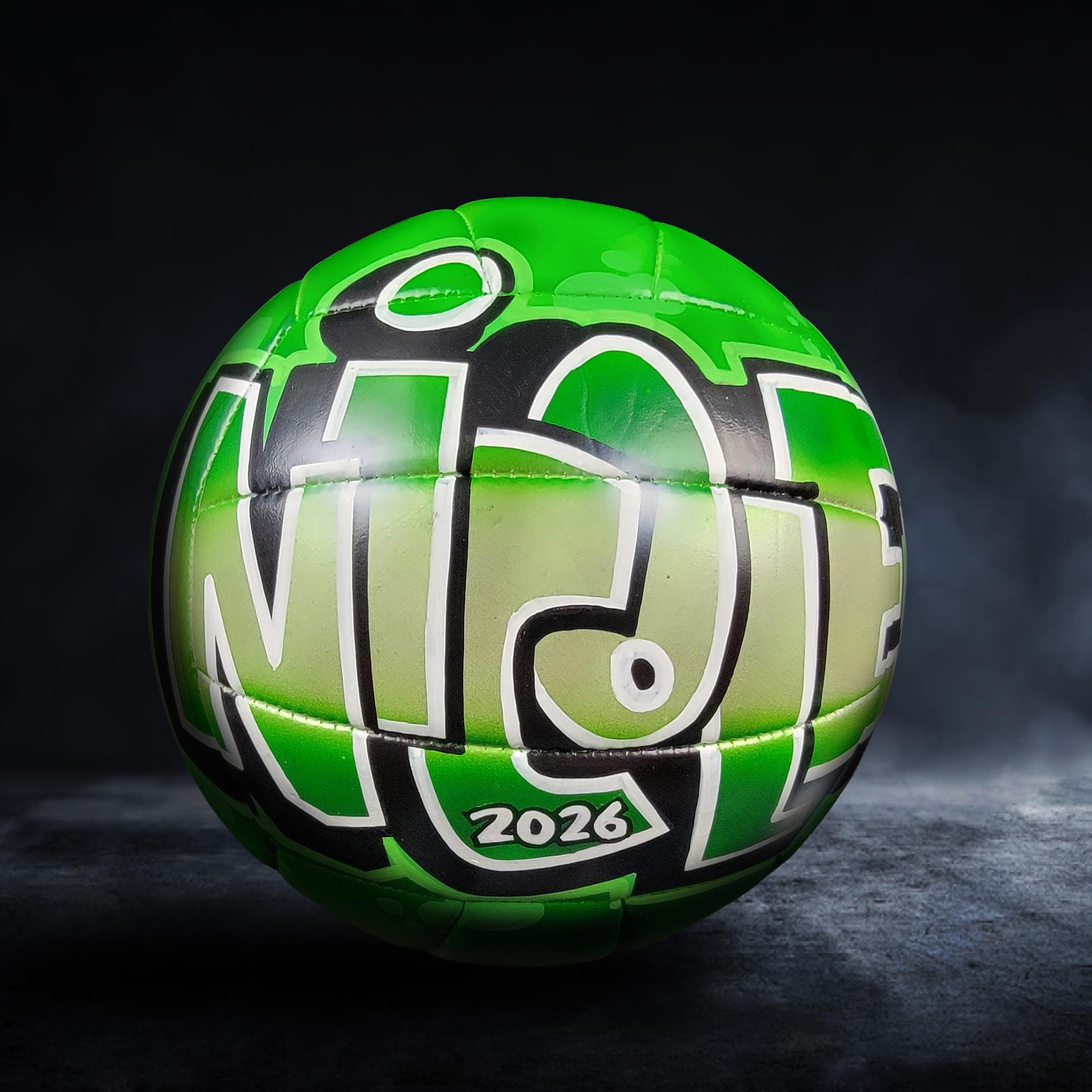 A green and black soccer ball with the text "NINE" painted on it.