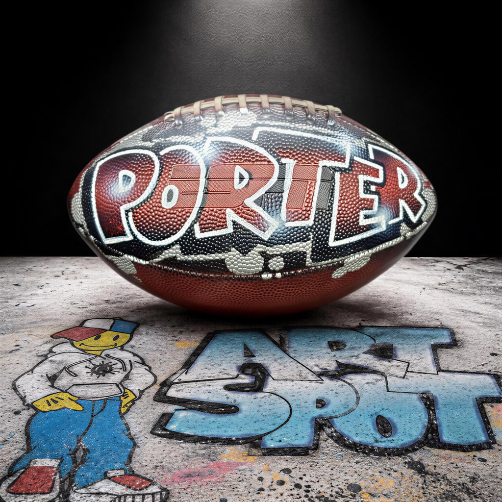 A football with the word "Porter" painted on it, sitting on a surface with graffiti and a cartoon character.