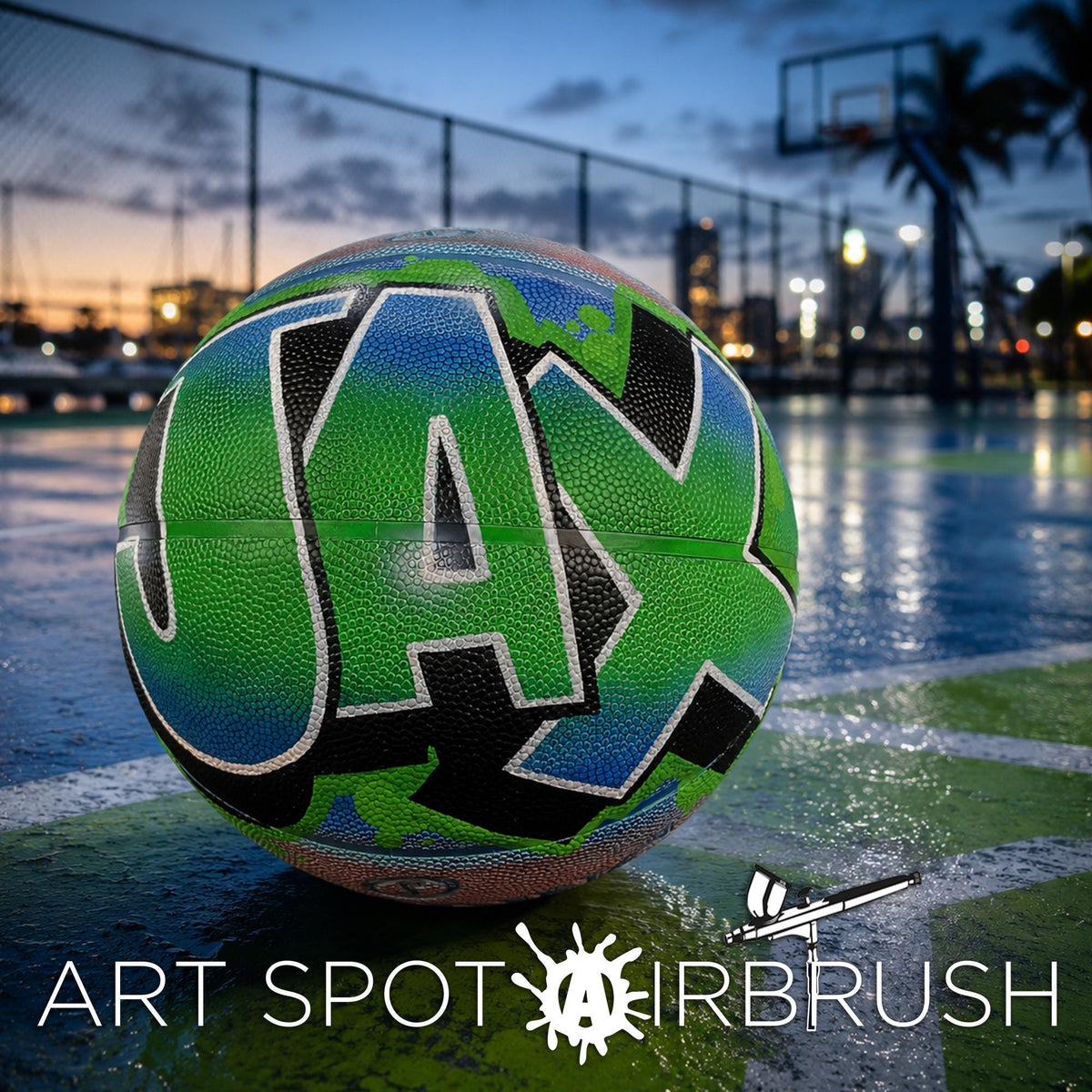 A colorful basketball with the word "JAX" painted on it, sitting on a basketball court at night.