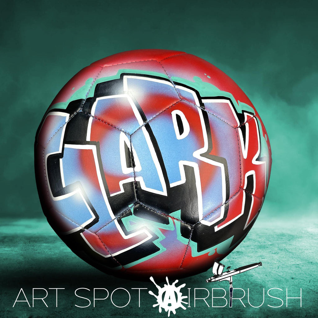 A soccer ball with the word "ART" painted on it, set against a green background.