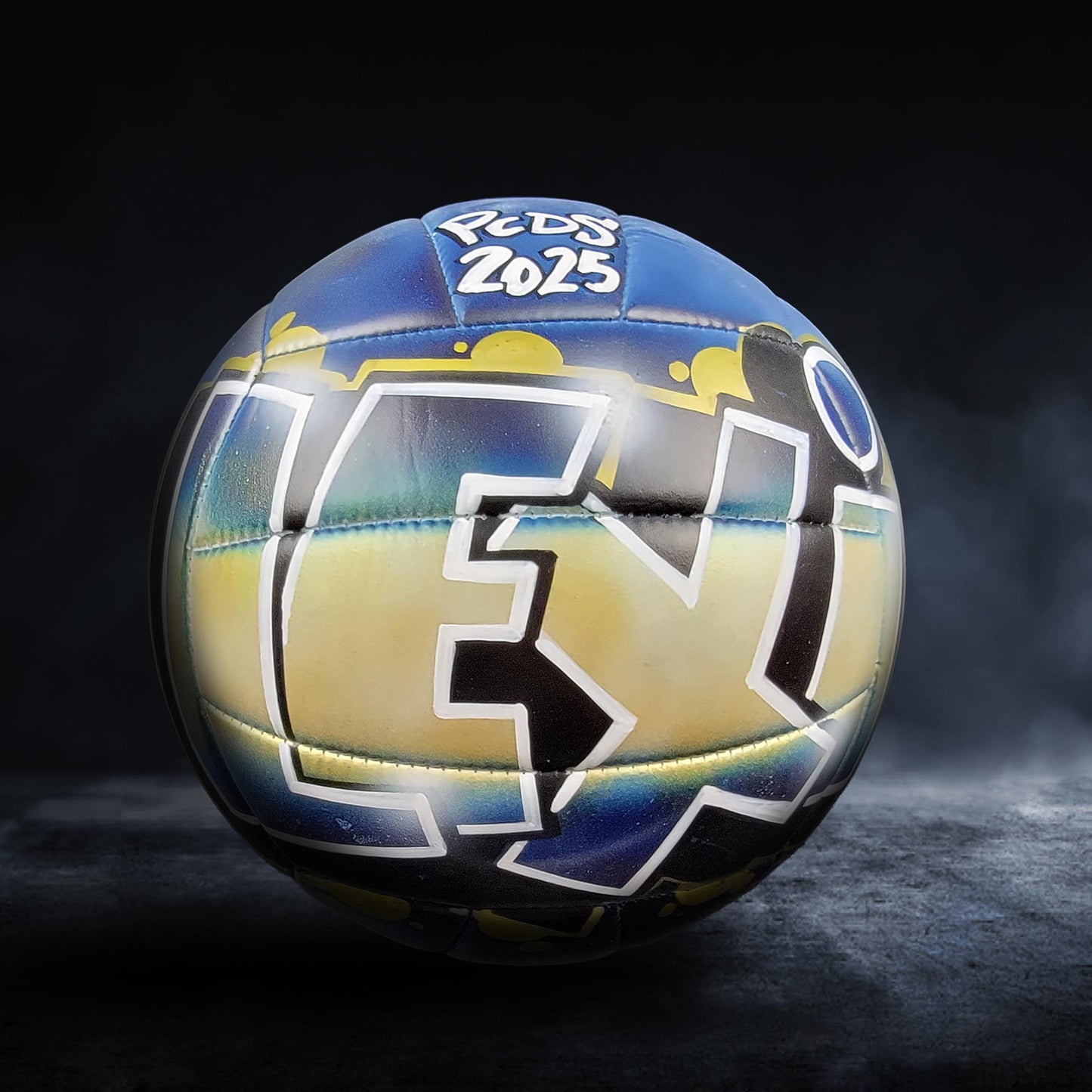 A soccer ball with a colorful, graffiti-style design on it, featuring the text "PEDS 2025" on the surface.