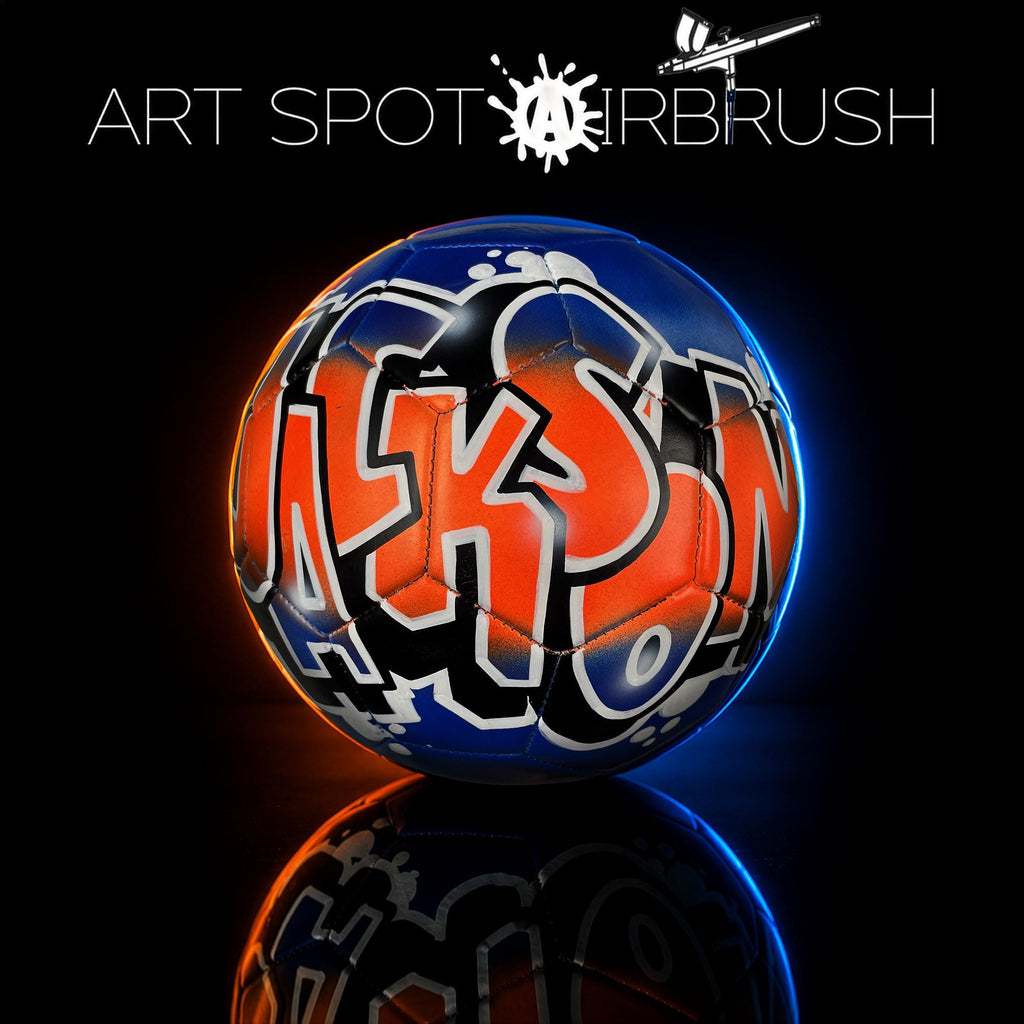 a soccer ball with graffiti on it, set against a dark background.