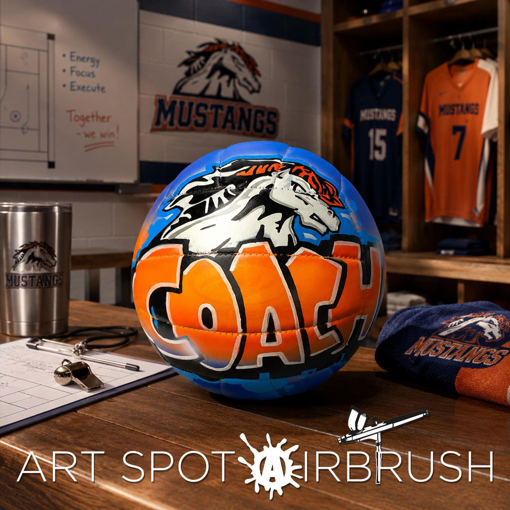 a blue and orange personalized custom volleyball with the word "COACH" written on it, along with various sports-related items such as a jersey, a cup, and a clipboard.