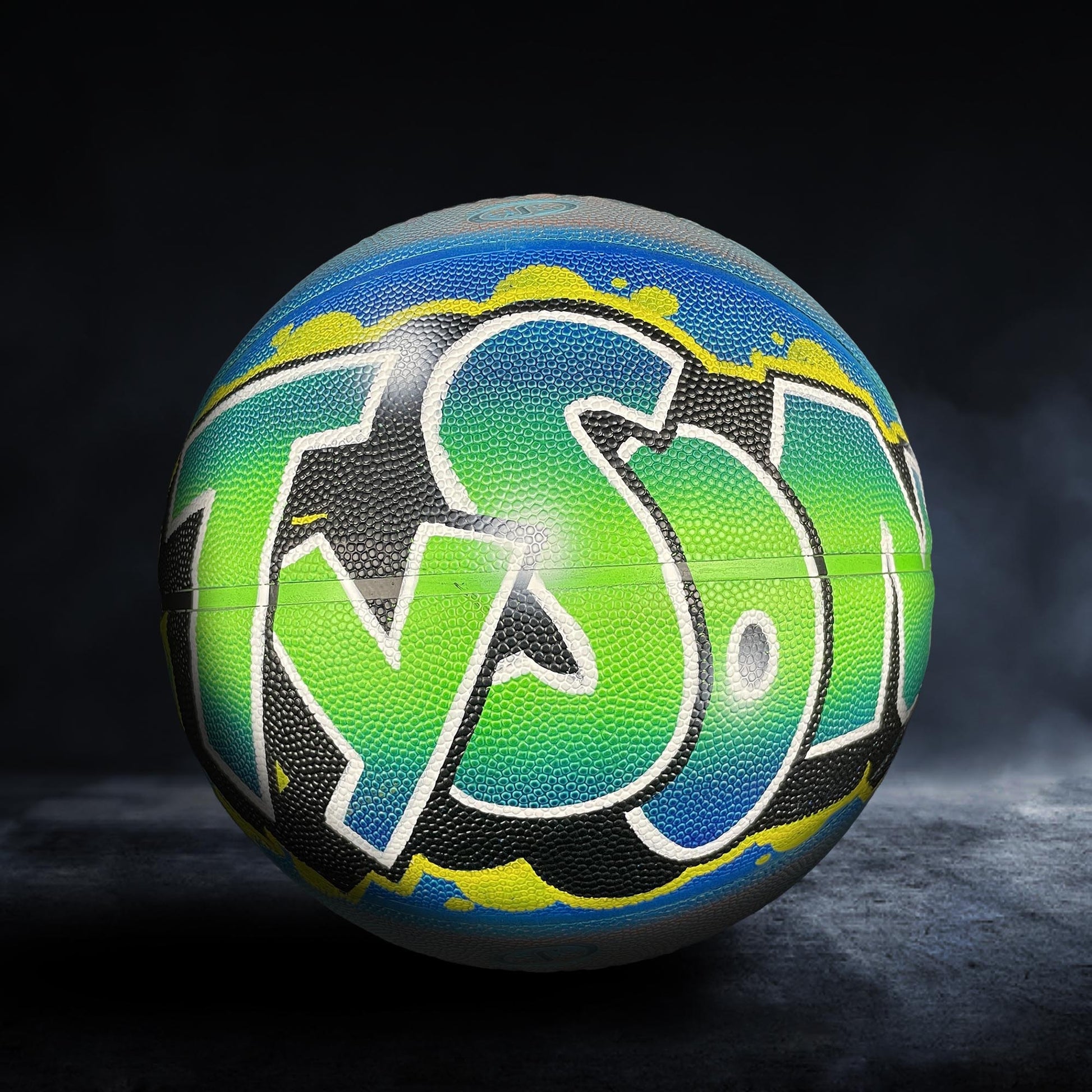 A colorful basketball with the word "TYSON" painted on it, set against a dark background.