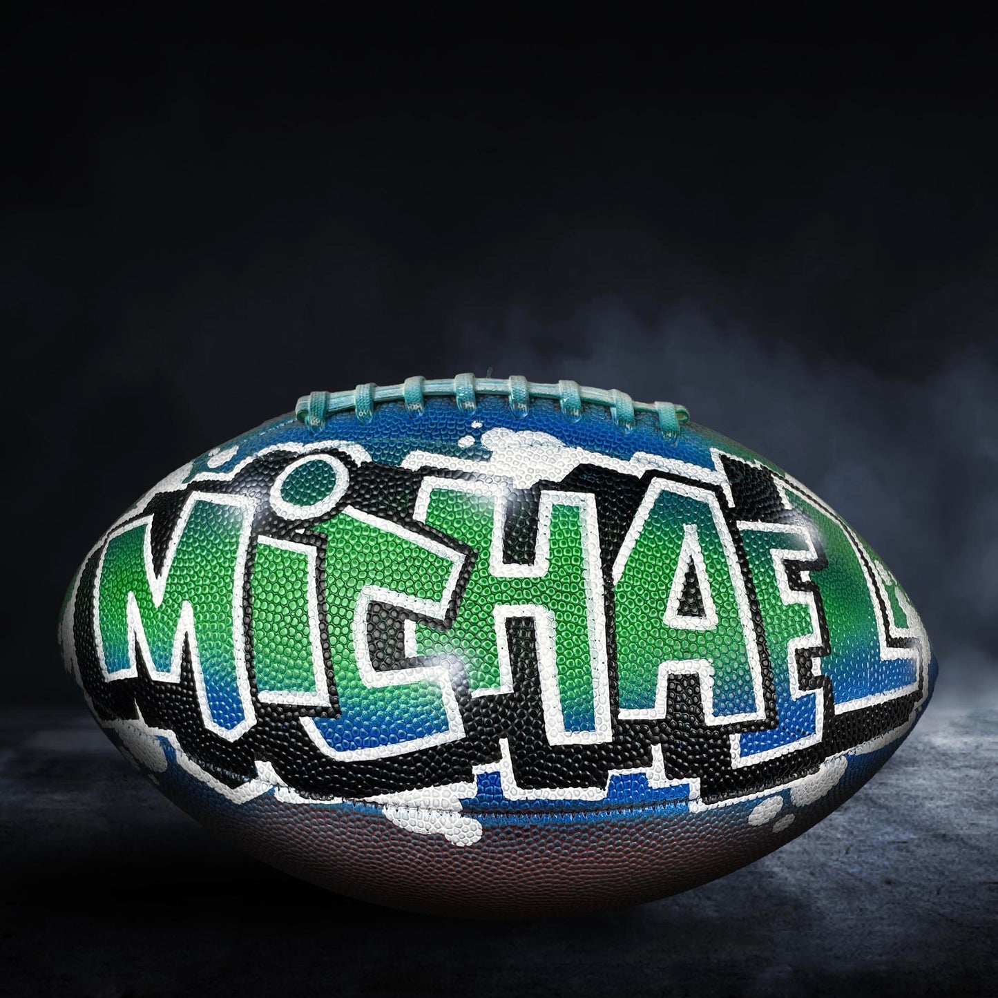 A personalized football with the name "MICHAEL" painted on it.