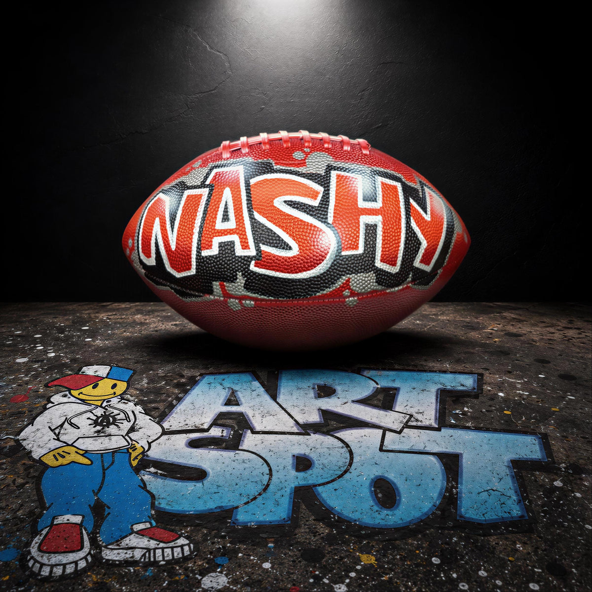 a red football with the word "NASHY" written on it, placed on a dark surface with graffiti-style text.