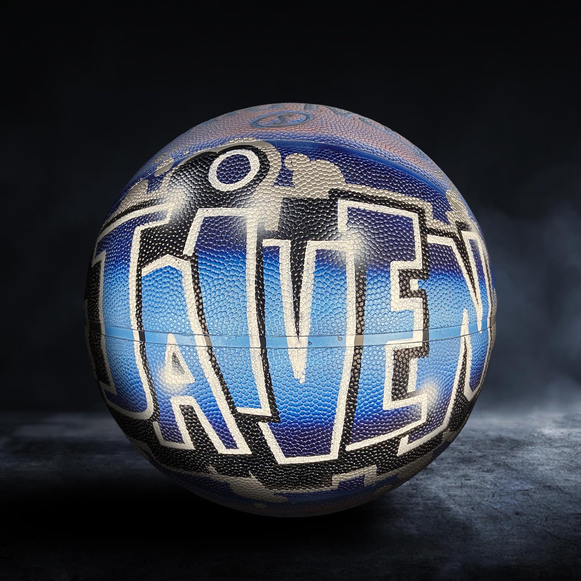 A basketball with the word "RAVEN" painted on it, which is a stylized representation of the word "RAVEN".