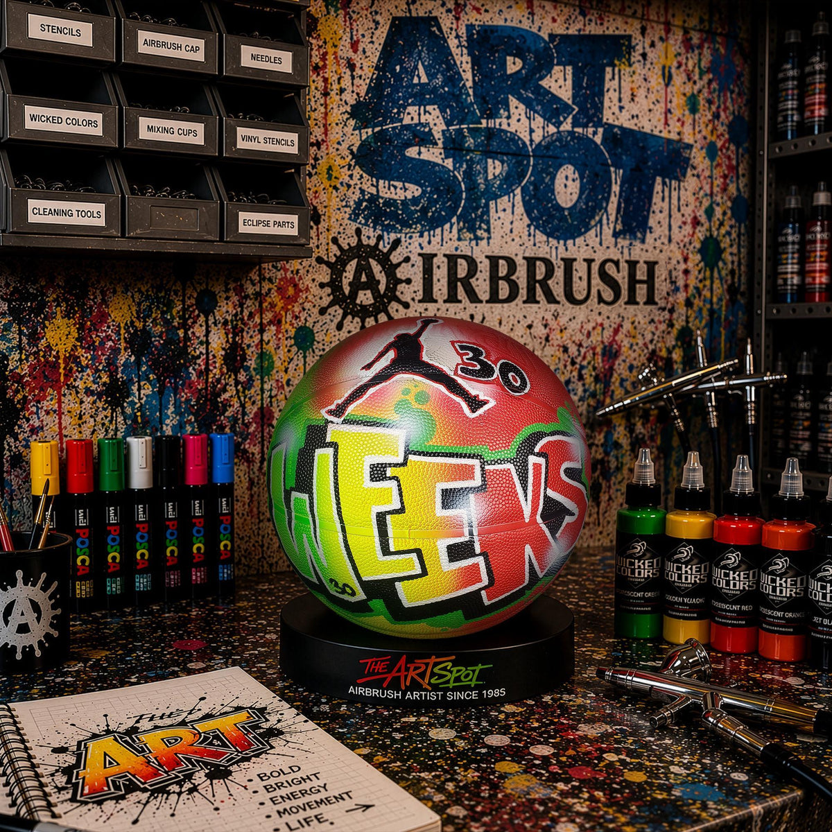 a vibrant and colorful workspace dedicated to airbrush art, with a variety of art supplies and tools displayed.
