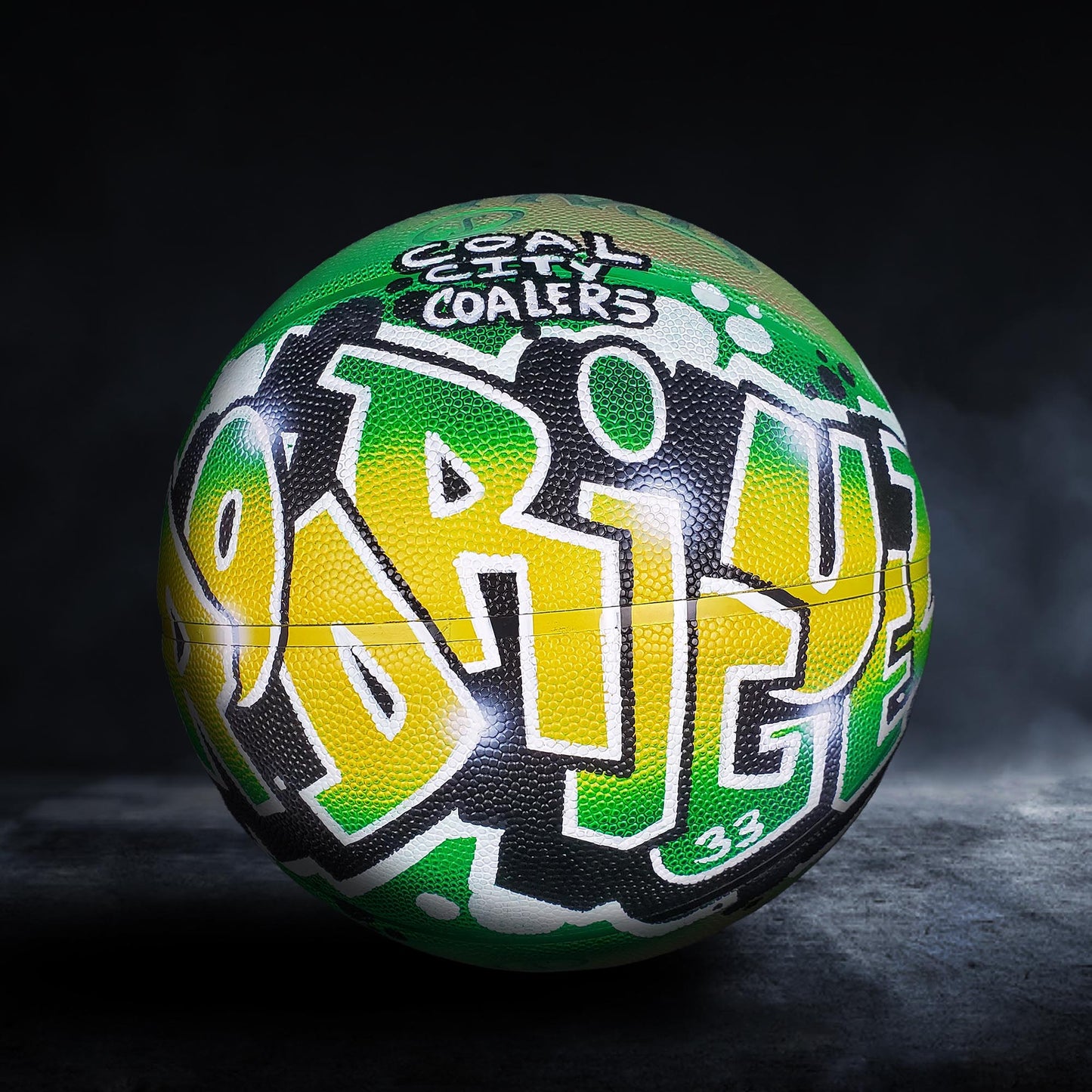 A basketball with a colorful, graffiti-style design on it, featuring the word "PRIDE" prominently displayed.